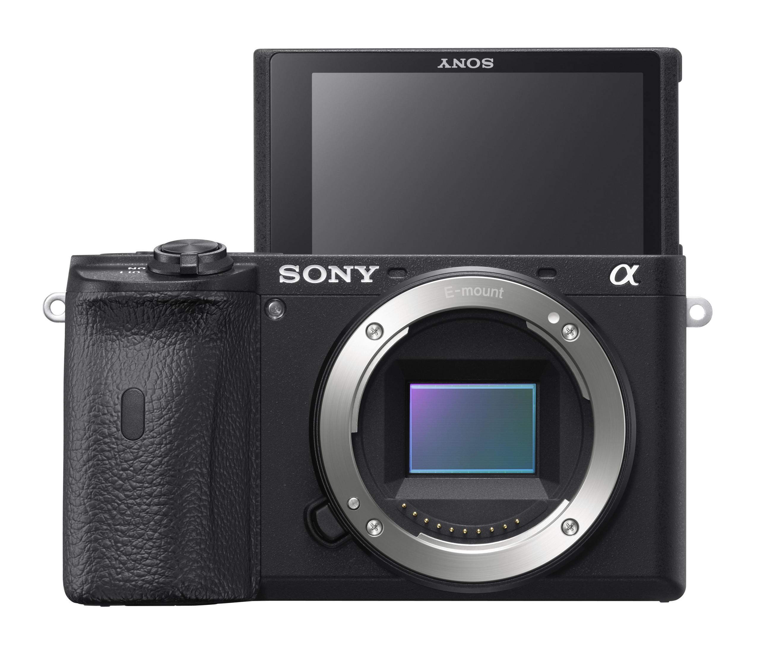 Schwarze Sony-Kamera mit geöffnetem Bildschirm und Objektiv, vor weißem Hintergrund.