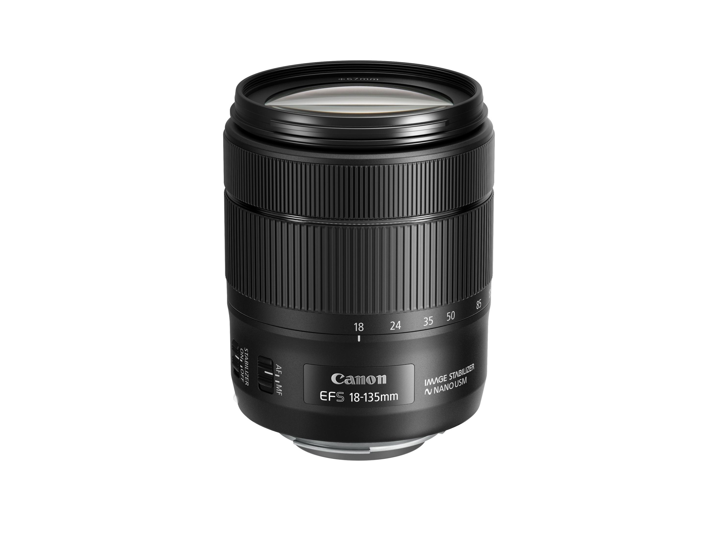 Objetivo Canon EFS 18-135mm. Negro, con anillos de enfoque y zoom, fondo blanco.