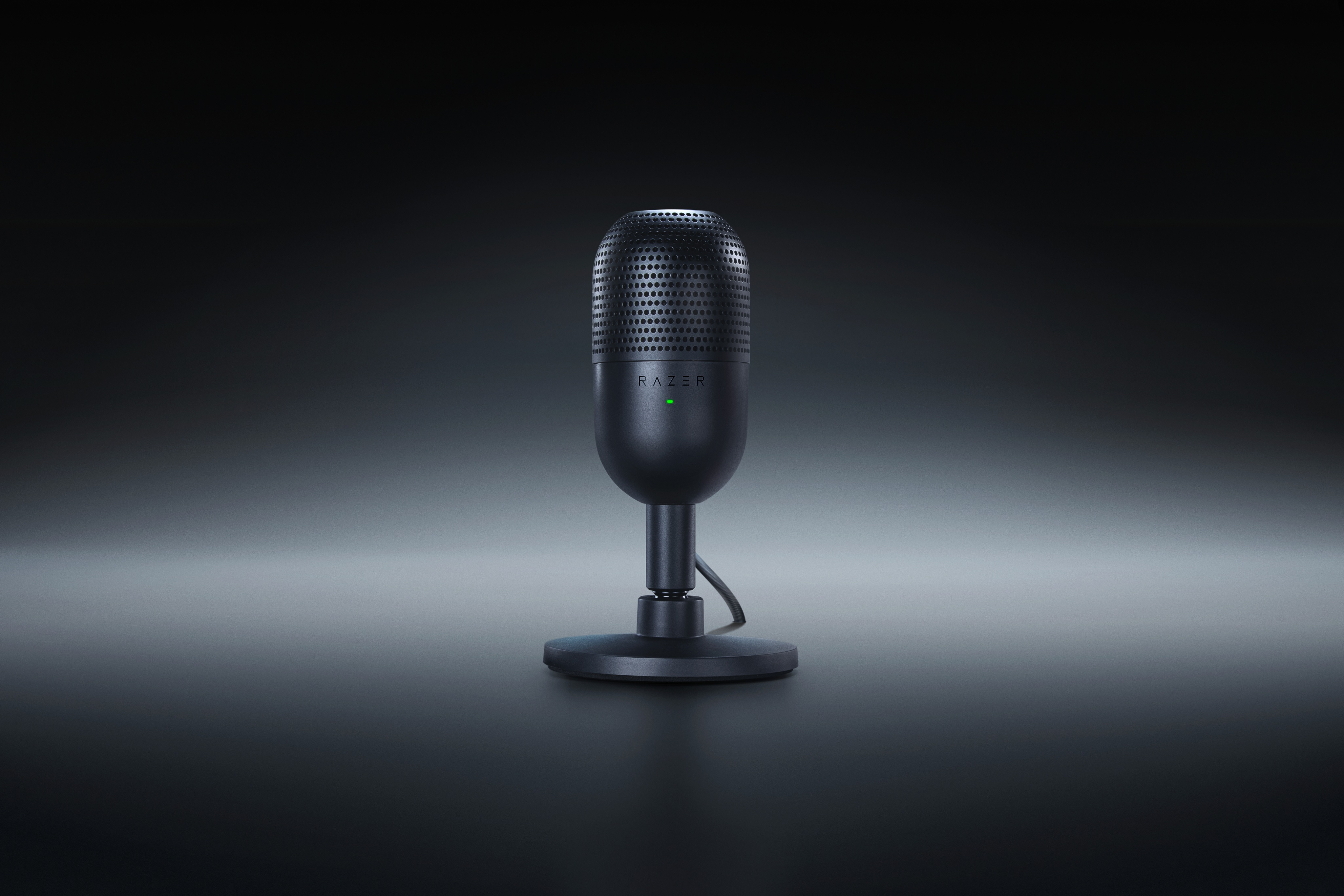 Microfono Razer nero con LED verde, su sfondo scuro sfumato.
