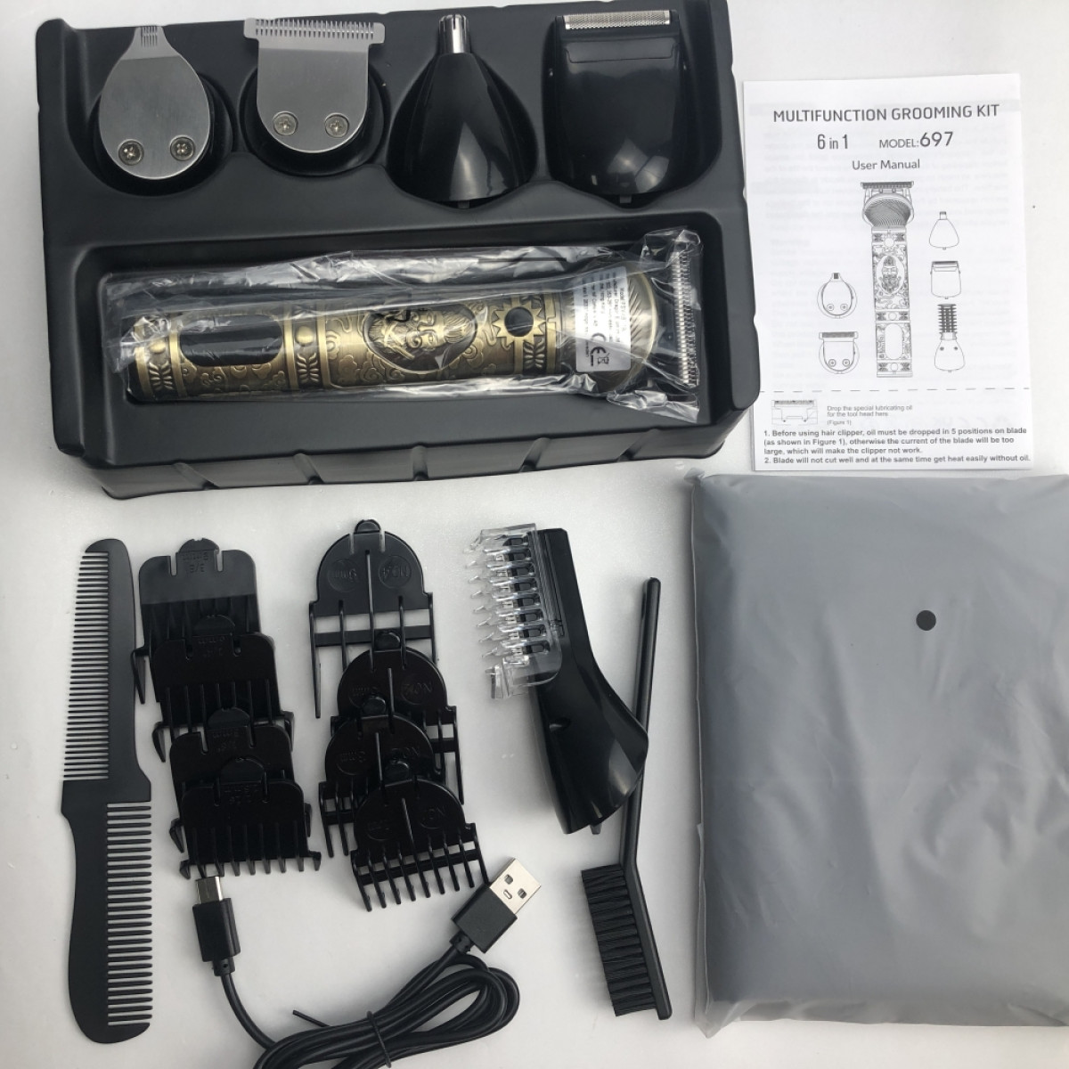 Schwarzes Pflege-Set mit mehreren Aufsätzen, einem Kamm und einer Bedienungsanleitung auf weißer Oberfläche.