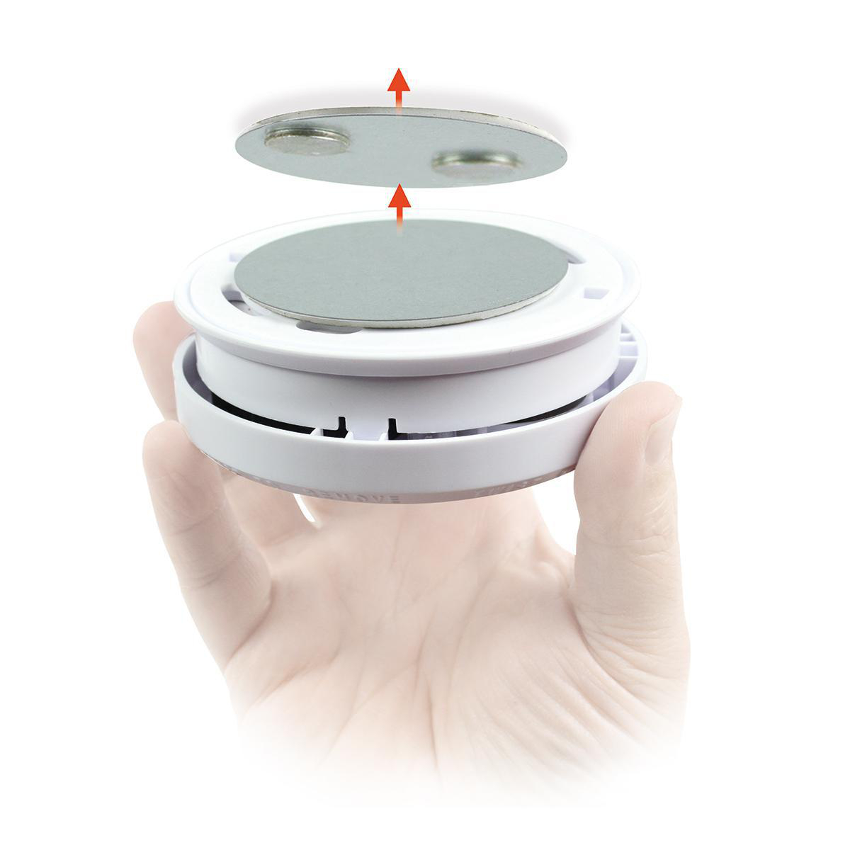 Mano che tiene dispositivo bianco con due dischi magnetici, uno viene posizionato sopra.