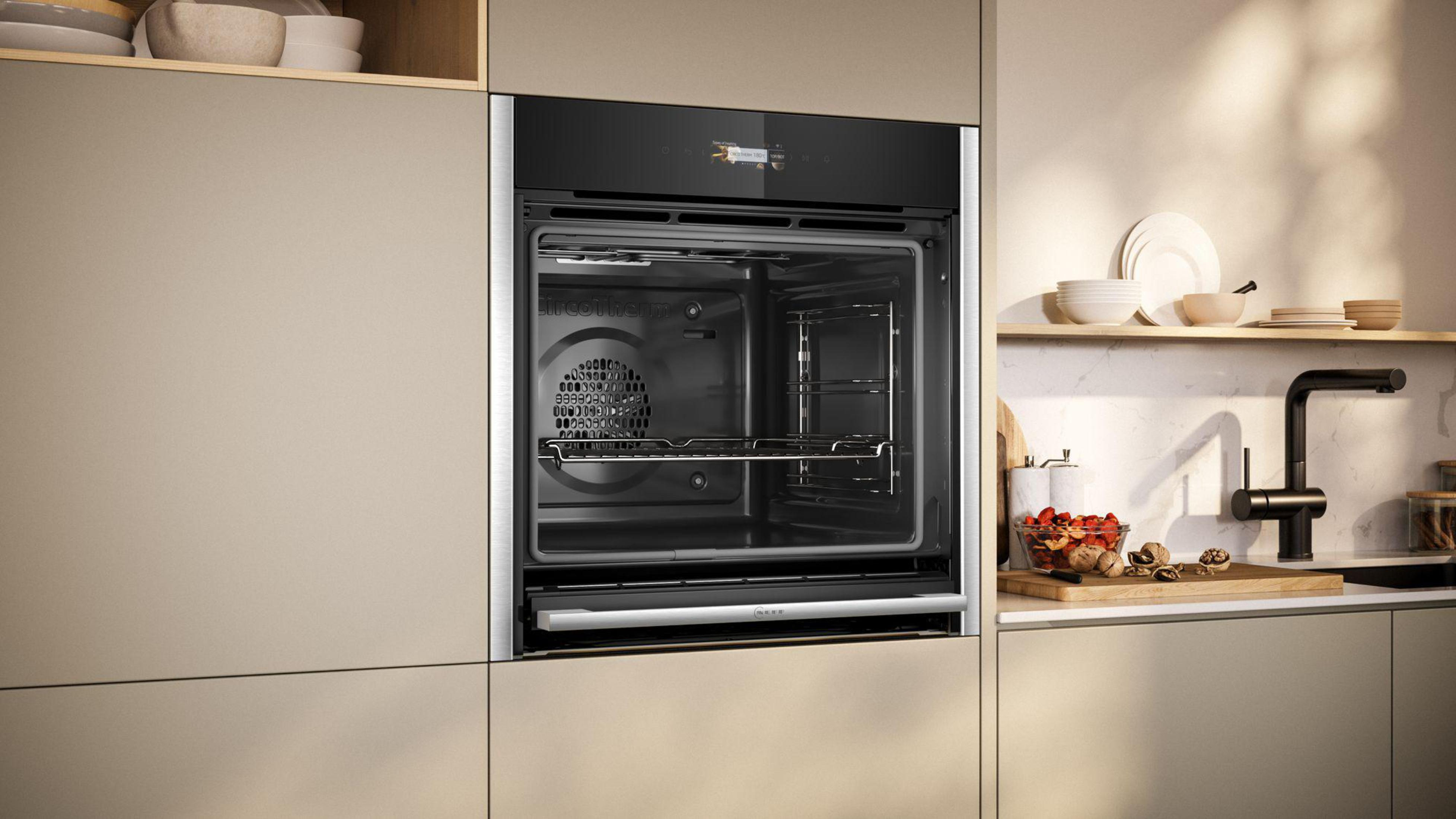 Einbau-Backofen in einer Küche. Die Backofentür ist geöffnet und zeigt das Innere und die Gestelle.