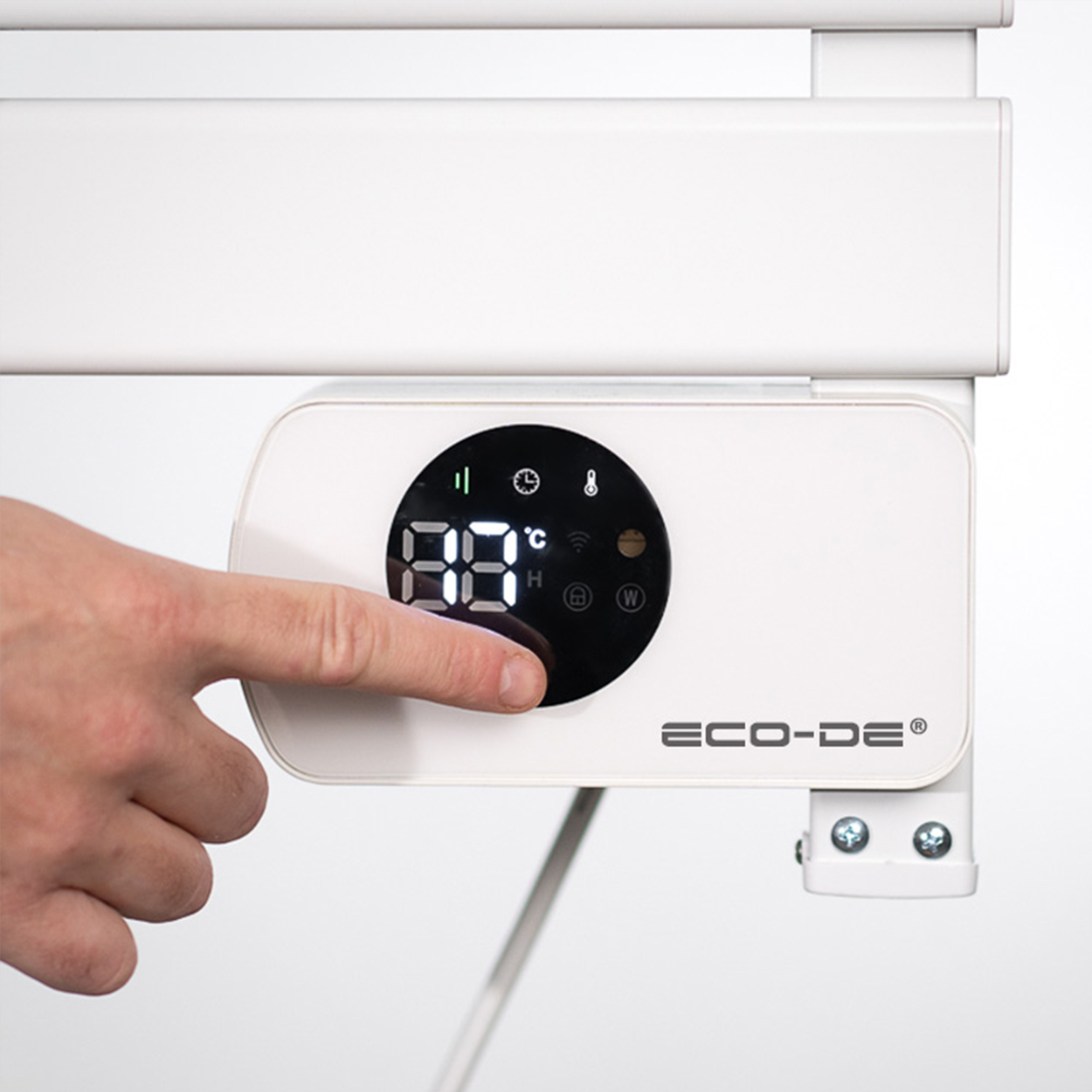 Una mano presionando un botón en un panel de control blanco con pantalla digital.