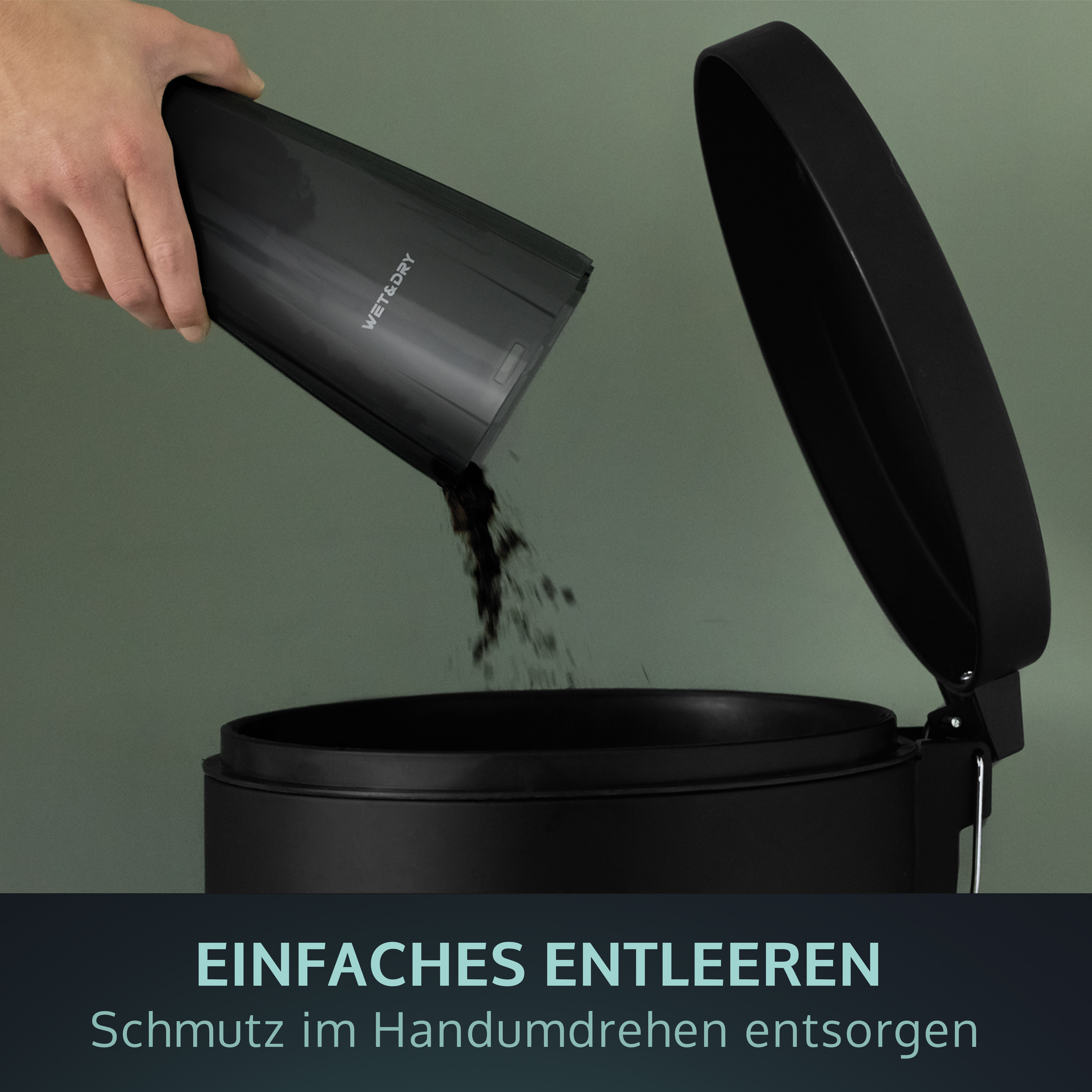 Eine Hand, die Schmutz aus einem schwarzen Behälter in einen schwarzen Mülleimer mit offenem Deckel gießt.