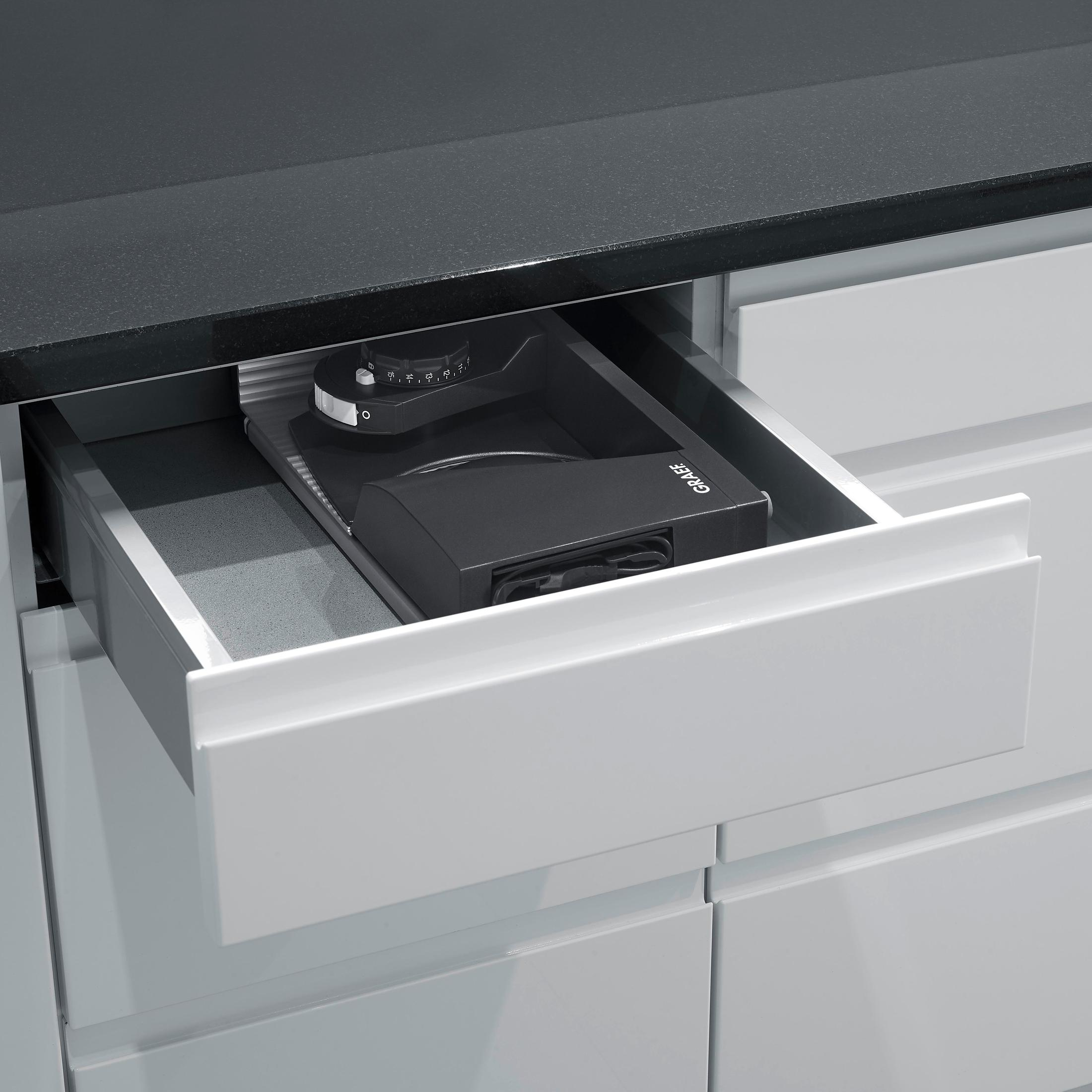 Un cassetto della cucina con un macinacaffè integrato. Il cassetto è aperto e un macinacaffè nero è visibile.