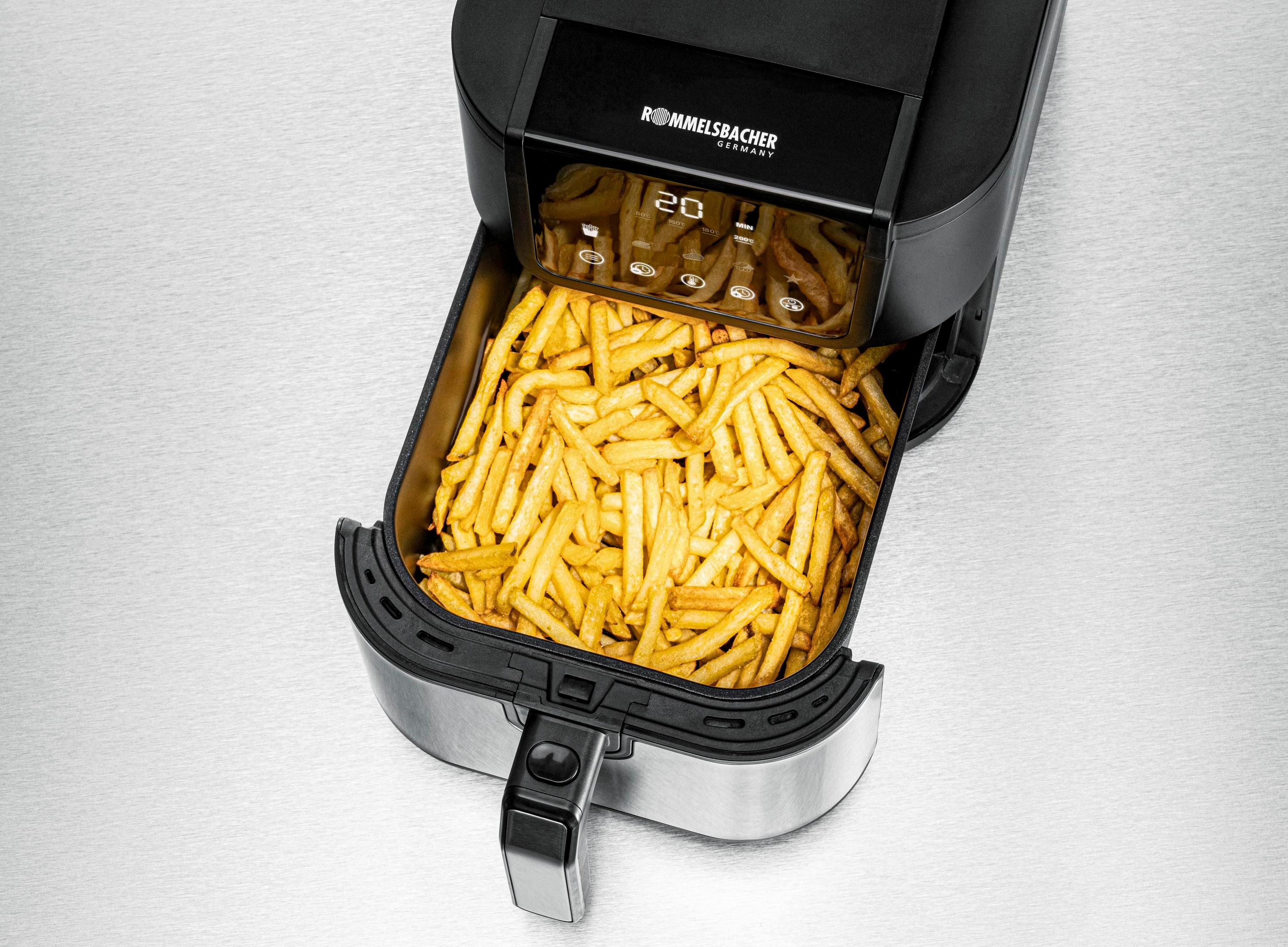 Szuflada frytownicy na powietrze wypełniona frytkami. Minutnik ustawiony na 20. Frytownica jest czarna i srebrna.
