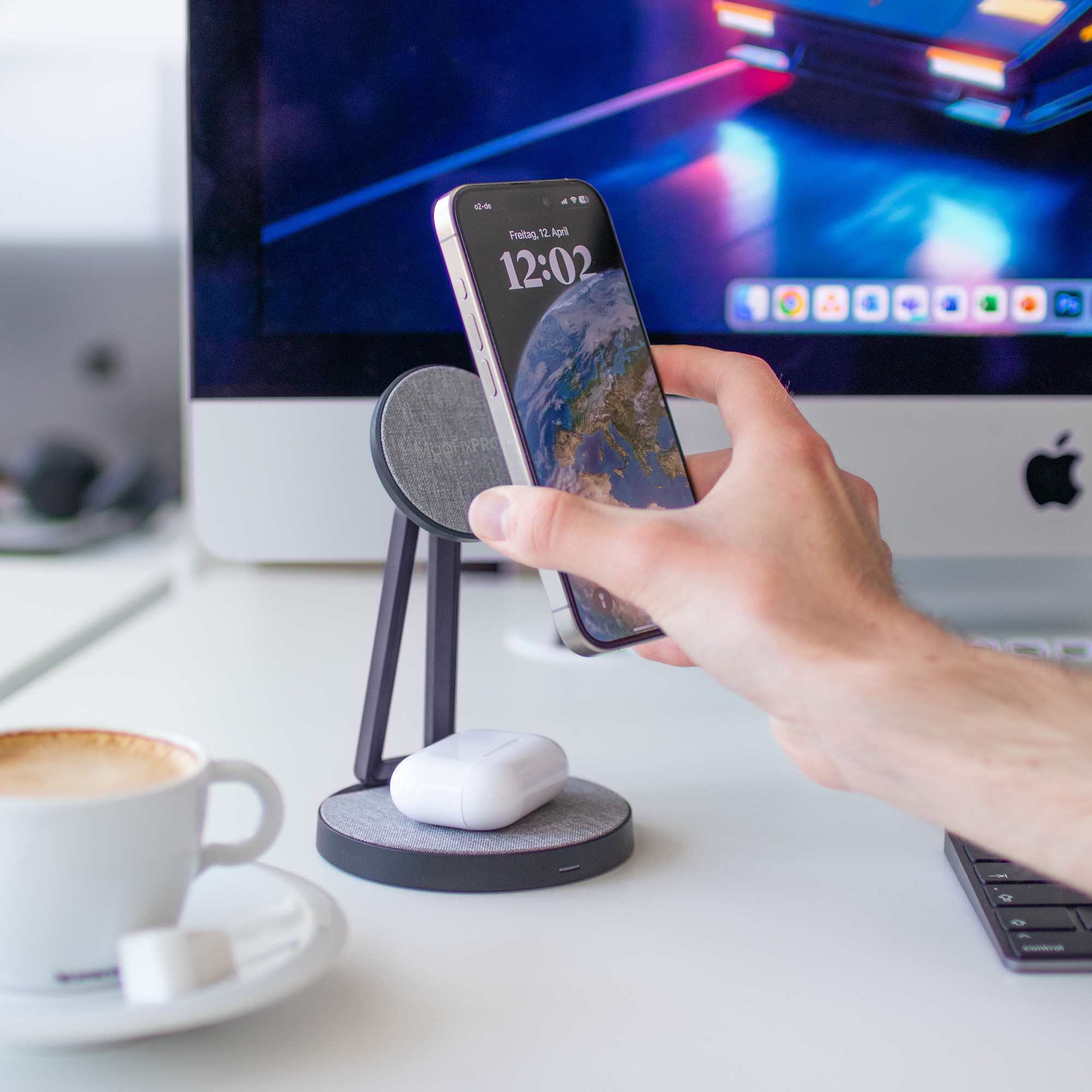 Eine Hand, die ein Telefon neben einem Ladeständer mit einem weißen AirPods-Etui hält.