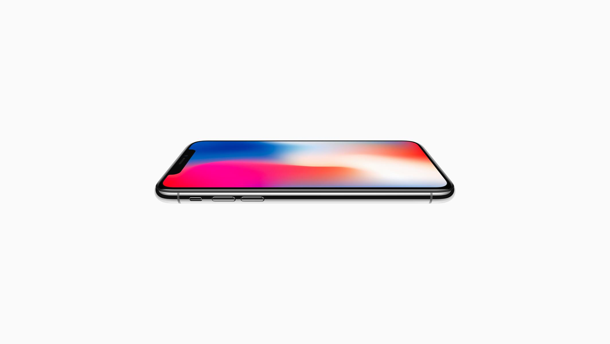 Un iPhone X de Apple, bordes plateados, pantalla negra, plano sobre superficie blanca, mostrando la pantalla.