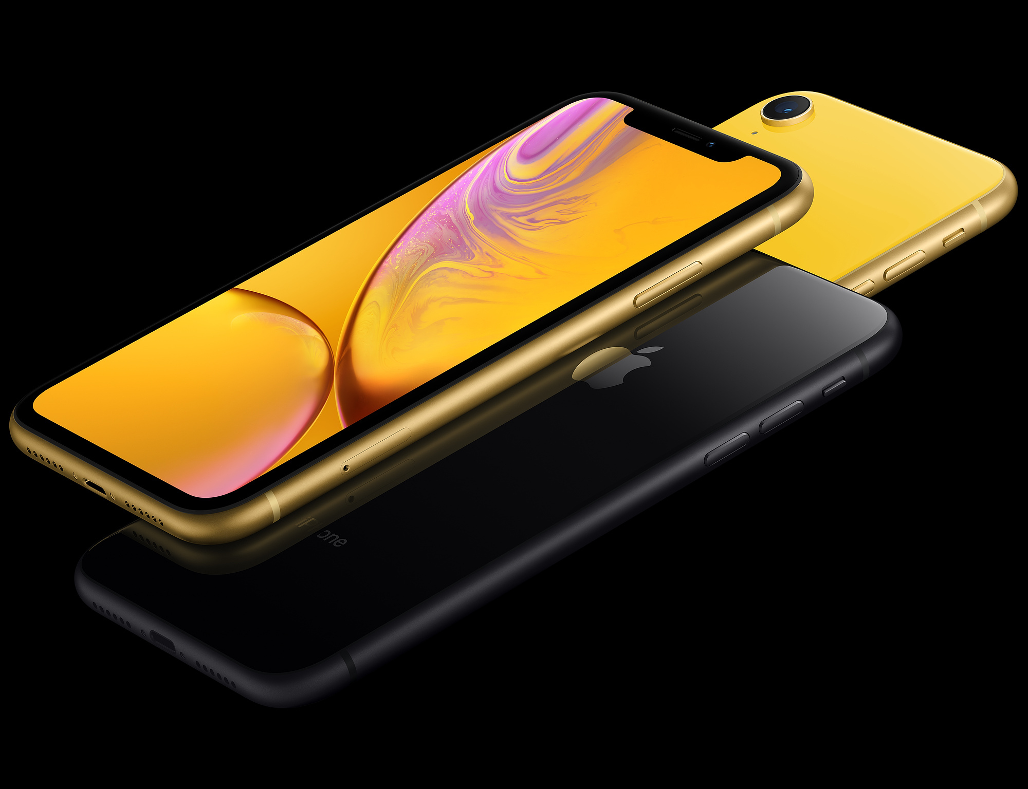 Trzy iPhone'y, złoty i czarny, na odblaskowej czarnej powierzchni, widok z boku.