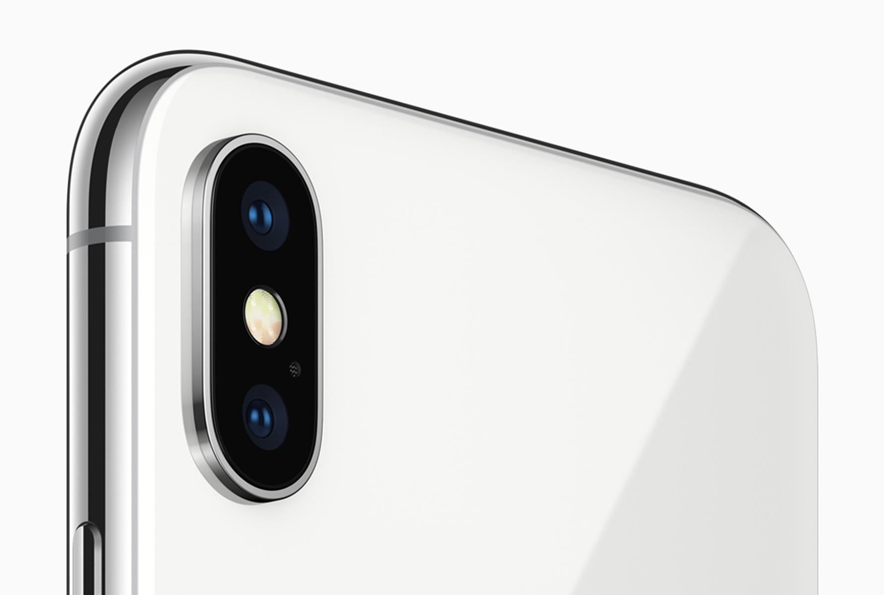 Primer plano de la parte trasera de un iPhone blanco. Tiene una cámara de doble lente y un marco plateado.