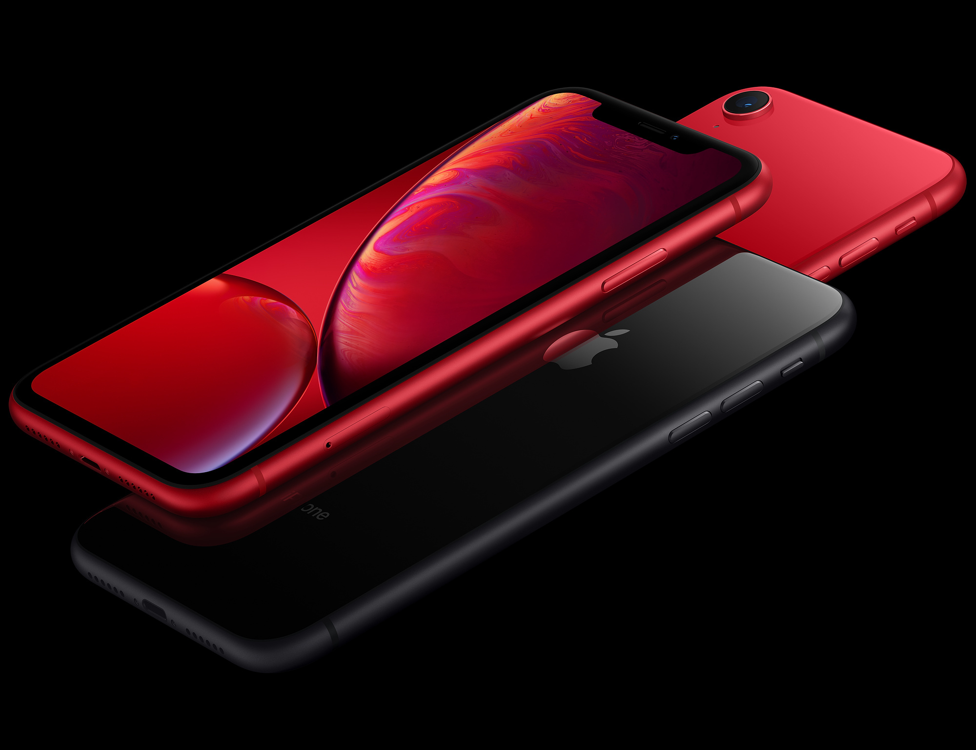 Tre iPhone, rosso e nero. Schermi accesi, con sfondi colorati. Sfondo nero.