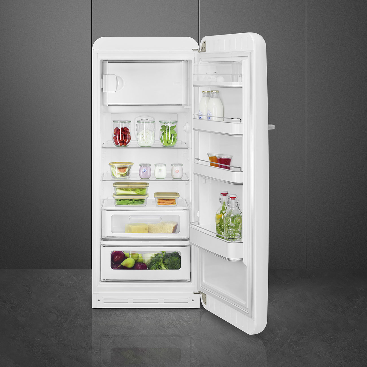 Ein weißer Kühlschrank im Retro-Stil mit offener Tür, zeigt Lebensmittel innen.
