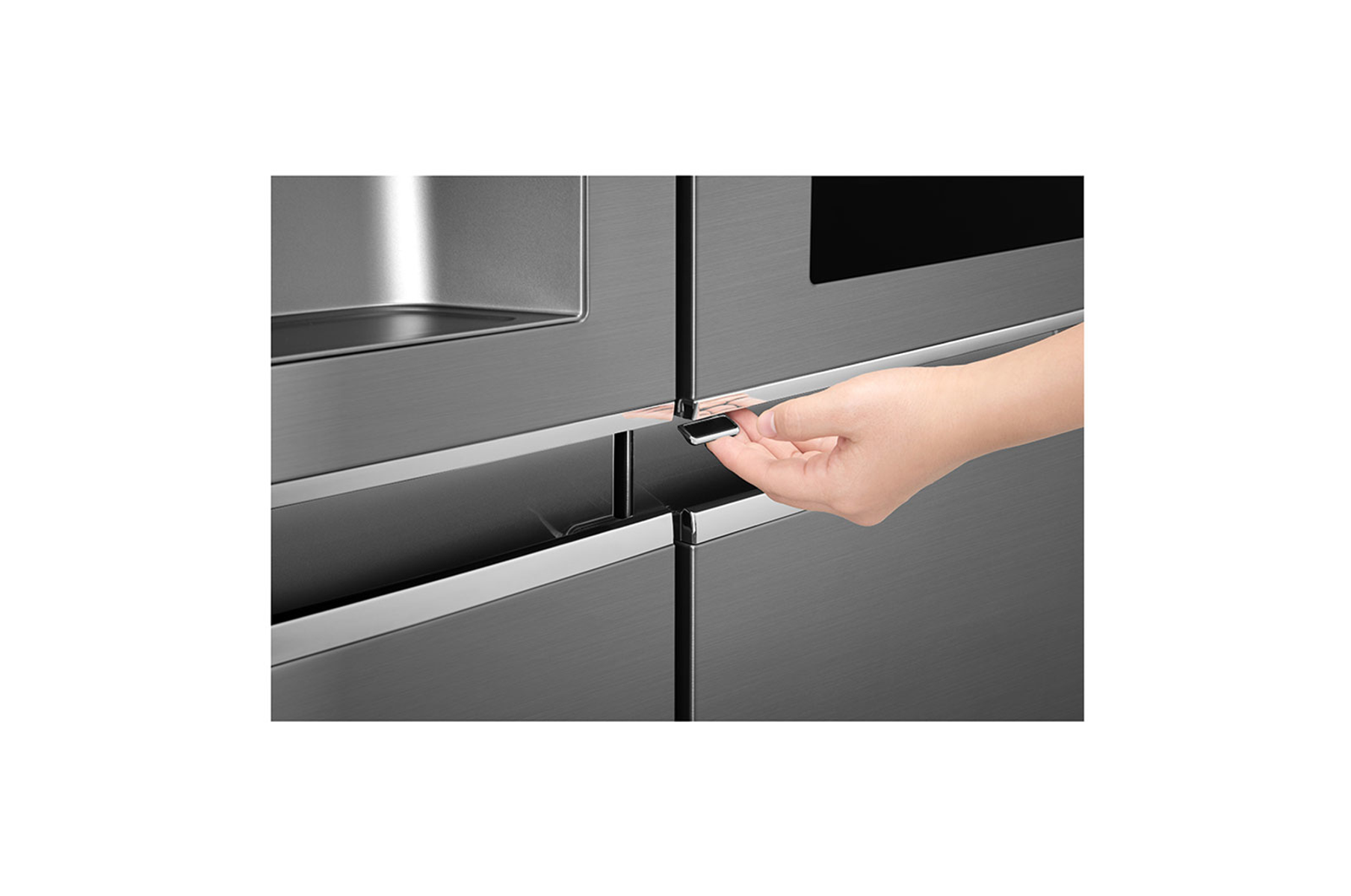 Una mano abre la puerta de un refrigerador gris oscuro. El refrigerador tiene un acabado metálico con detalles plateados.