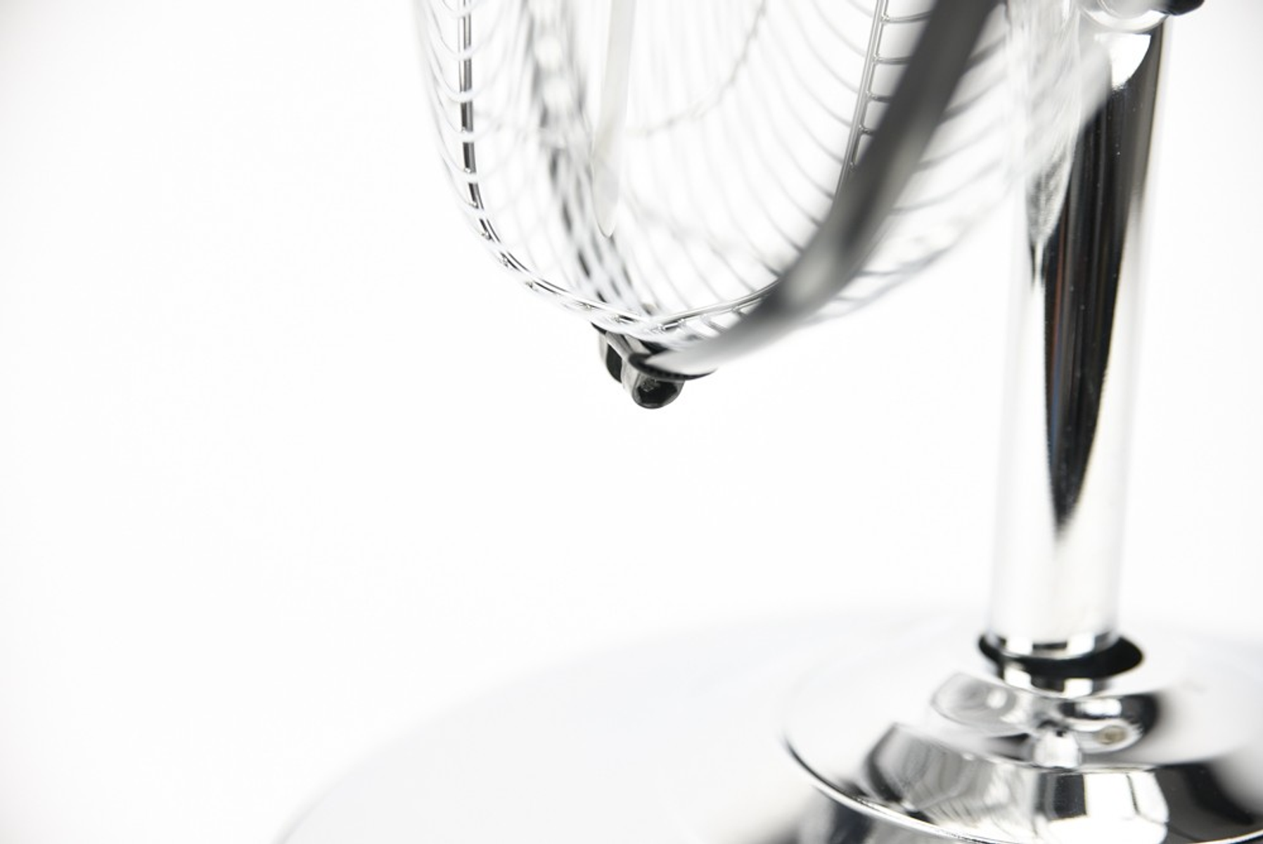 Ein Chrom-Ventilator mit Metallrahmen, isoliert auf weißem Hintergrund.