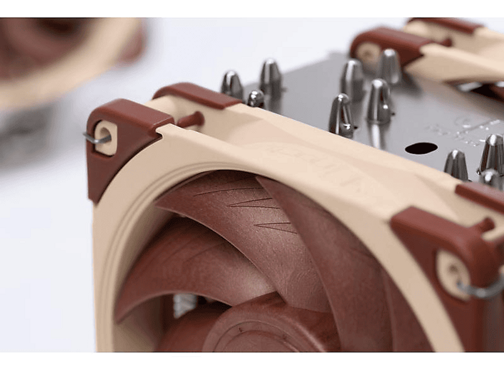 Zbliżenie na wentylator komputera z brązowymi łopatkami i beżową ramą.