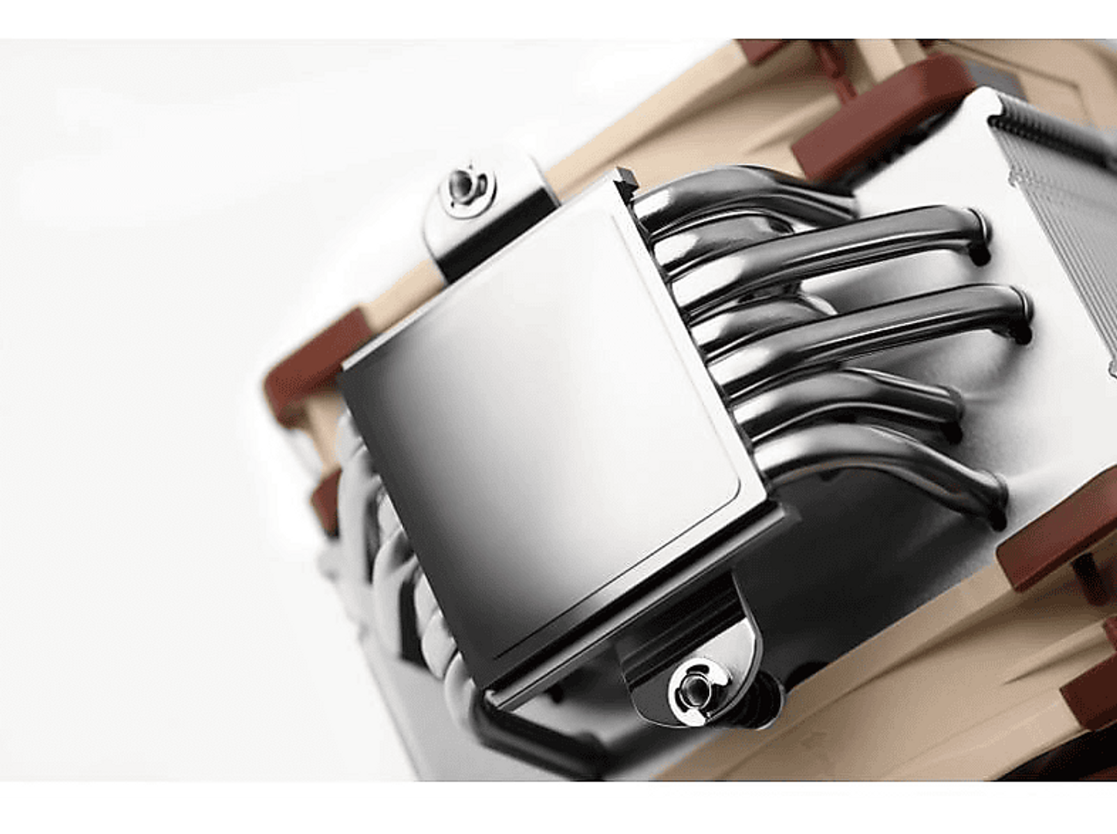 Zbliżenie elementu komputera ze srebrnym kwadratem i czarnymi rurkami.