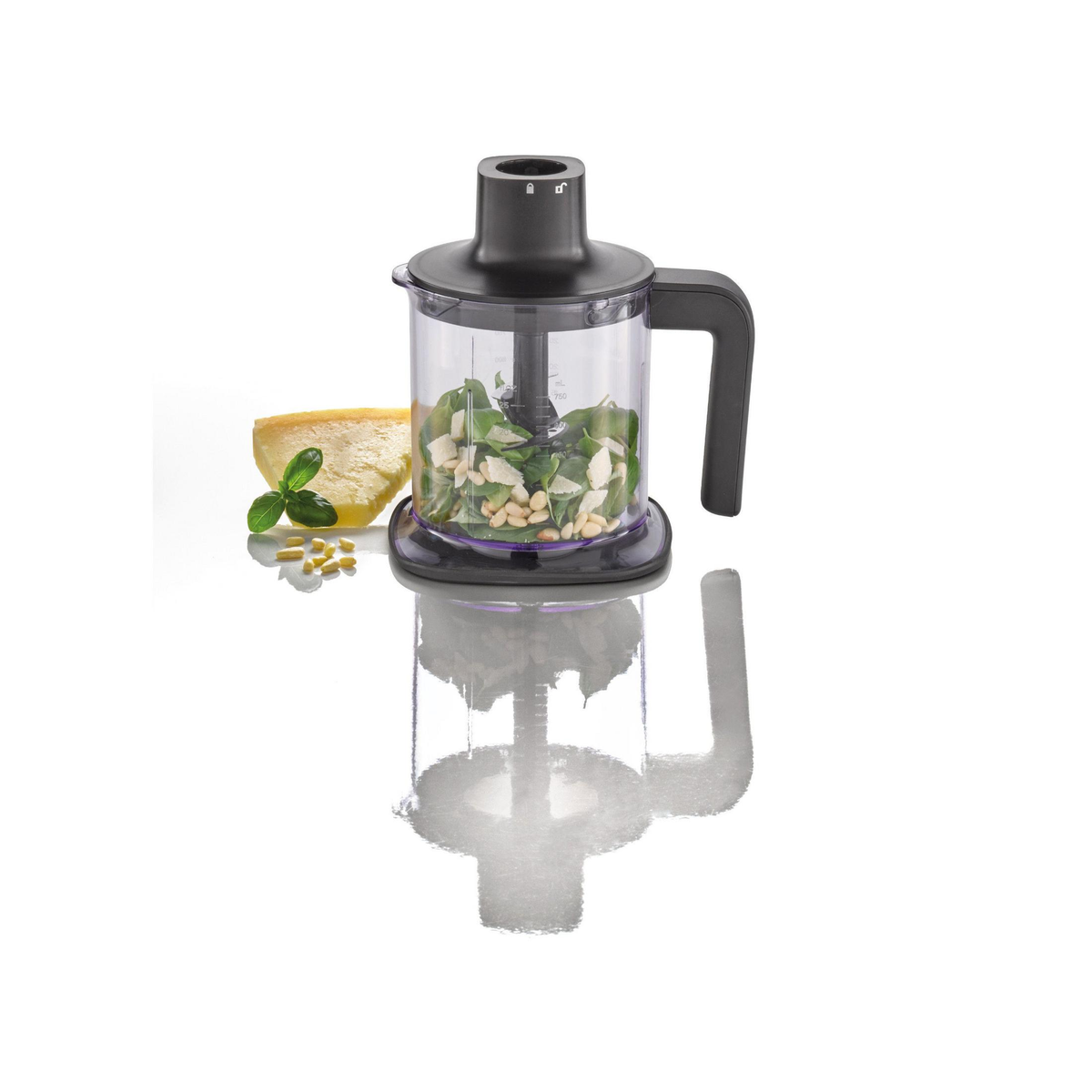 Mixer mit Pesto-Zutaten: Basilikum, Pinienkerne, Käse und ein Löffel.