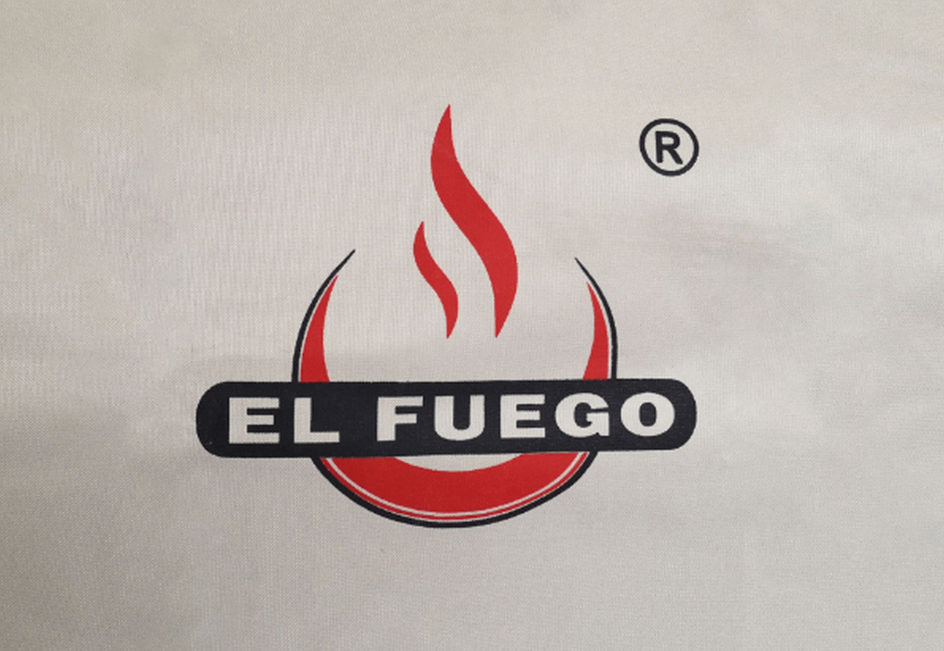 Weißer Stoff mit rotem Flammenlogo und schwarzem Text: El Fuego. Weißer Hintergrund.