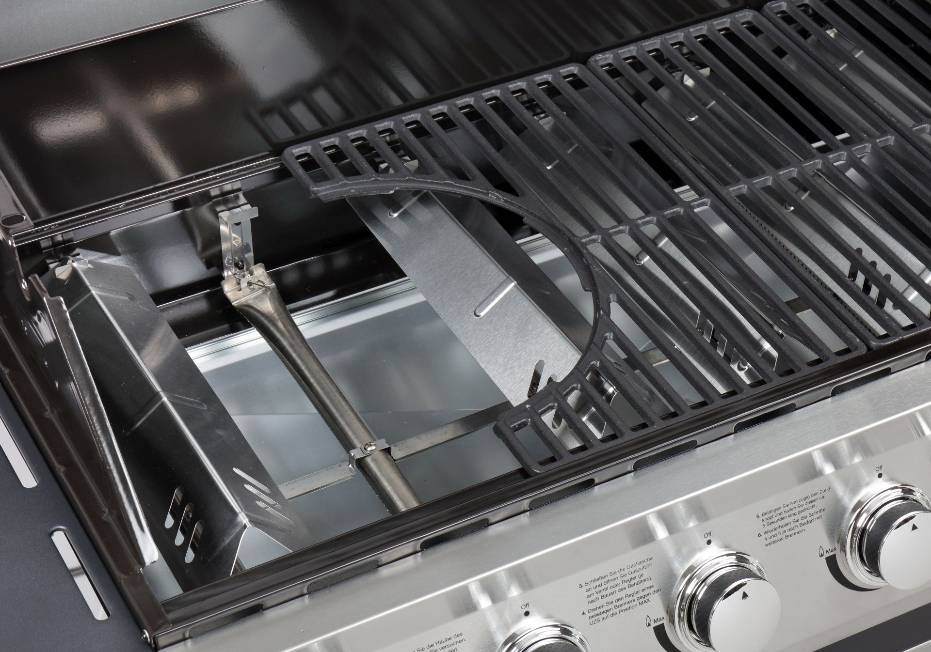 Nahaufnahme eines Grills mit Metallbrennern, Teil eines größeren Grills.