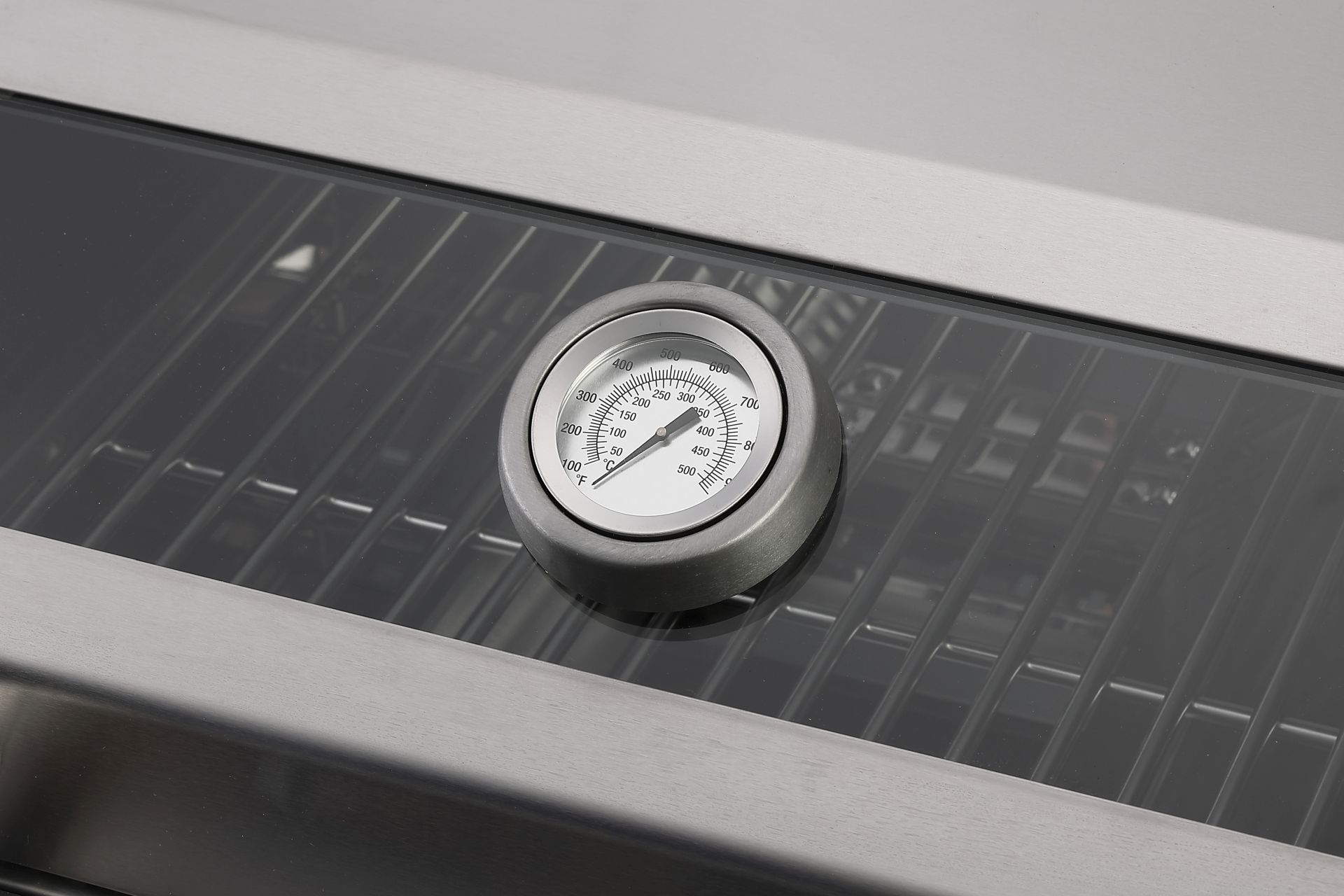 Ein Grill mit Thermometer, das die Temperatur anzeigt. Der Grill ist aus Edelstahl.