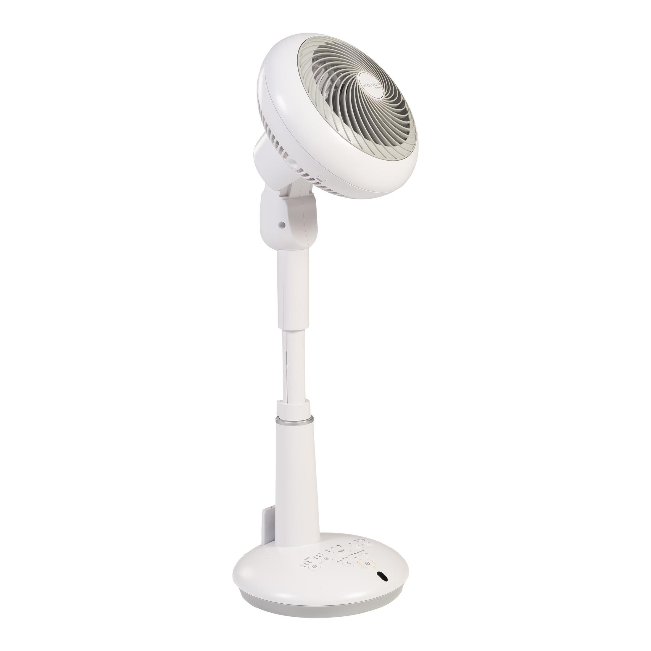 Ventilador de pie blanco sobre fondo blanco, inclinado hacia el espectador.