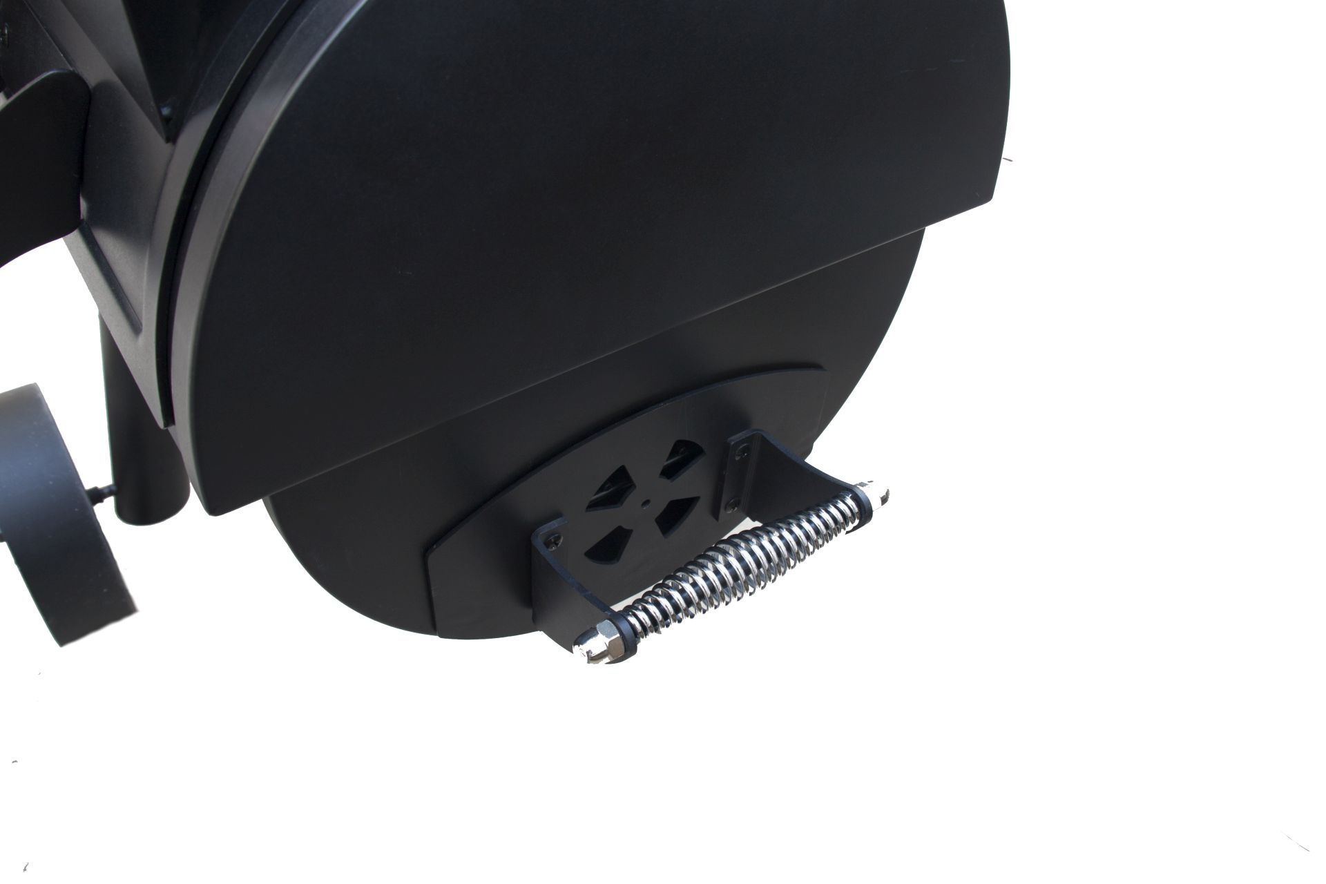 Nahaufnahme der Seite eines schwarzen Grills. Es gibt einen Griff und ein Lüftungsdetail.