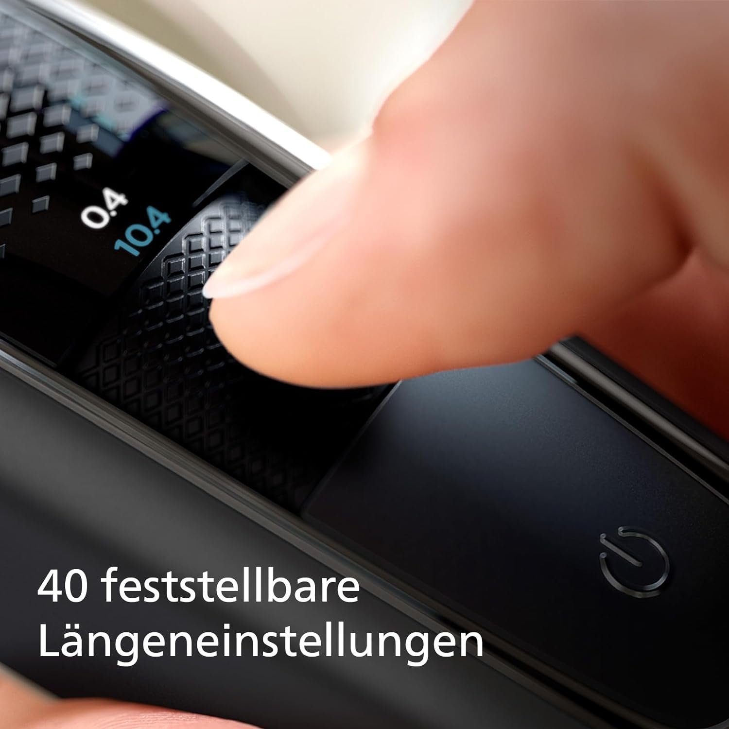 Eine Hand stellt an einem schwarzen Elektrorasierer einen Drehregler ein.