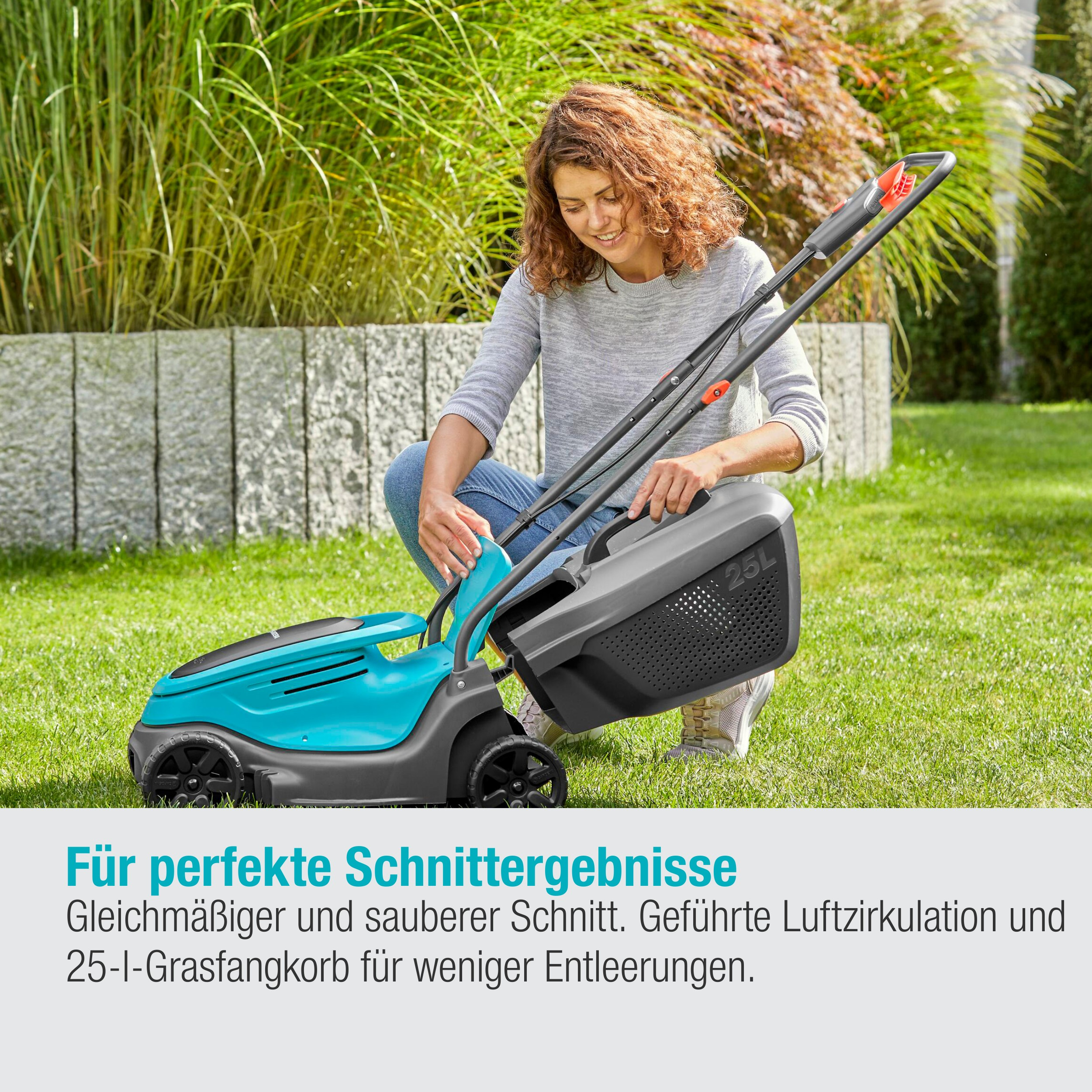 Frau benutzt einen Rasenmäher auf einem grünen Rasen.