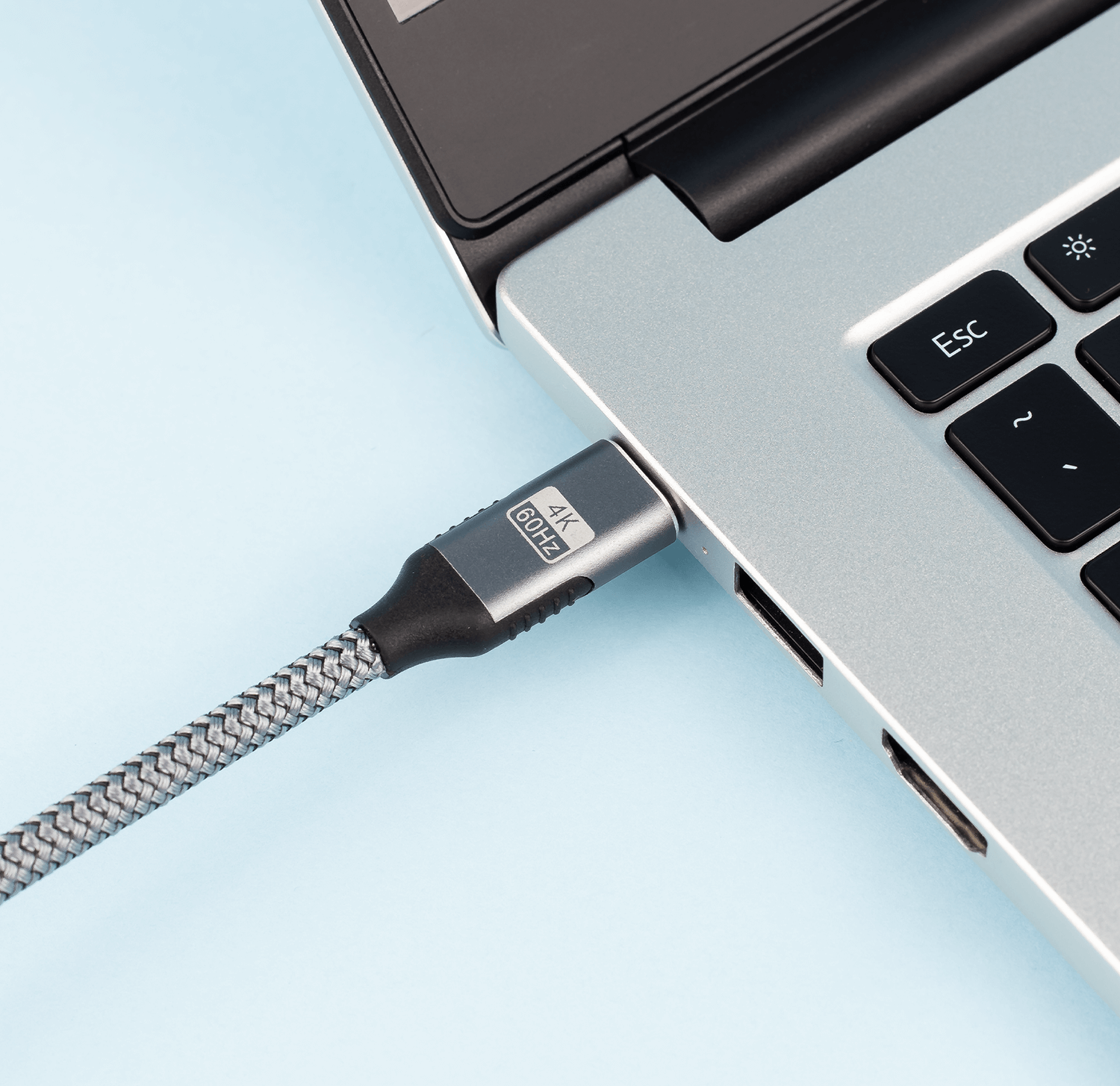 Kabel USB-C podłączony do laptopa. Kabel jest szary.