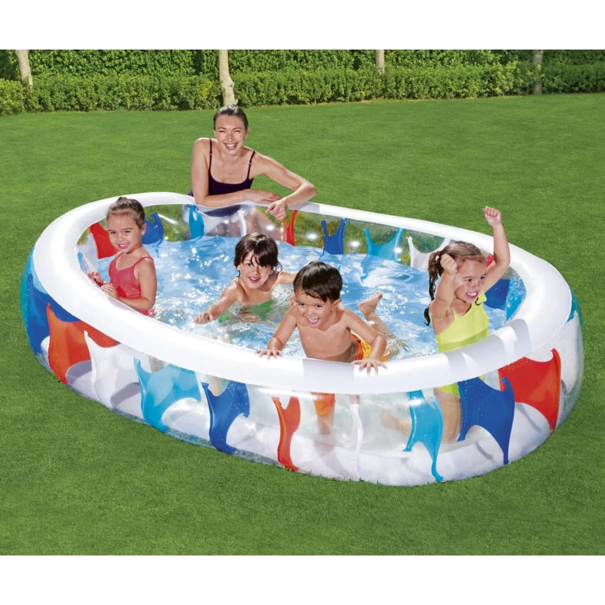 Enfants jouant dans une piscine gonflable bleue, blanche et rouge avec une femme en arrière-plan.