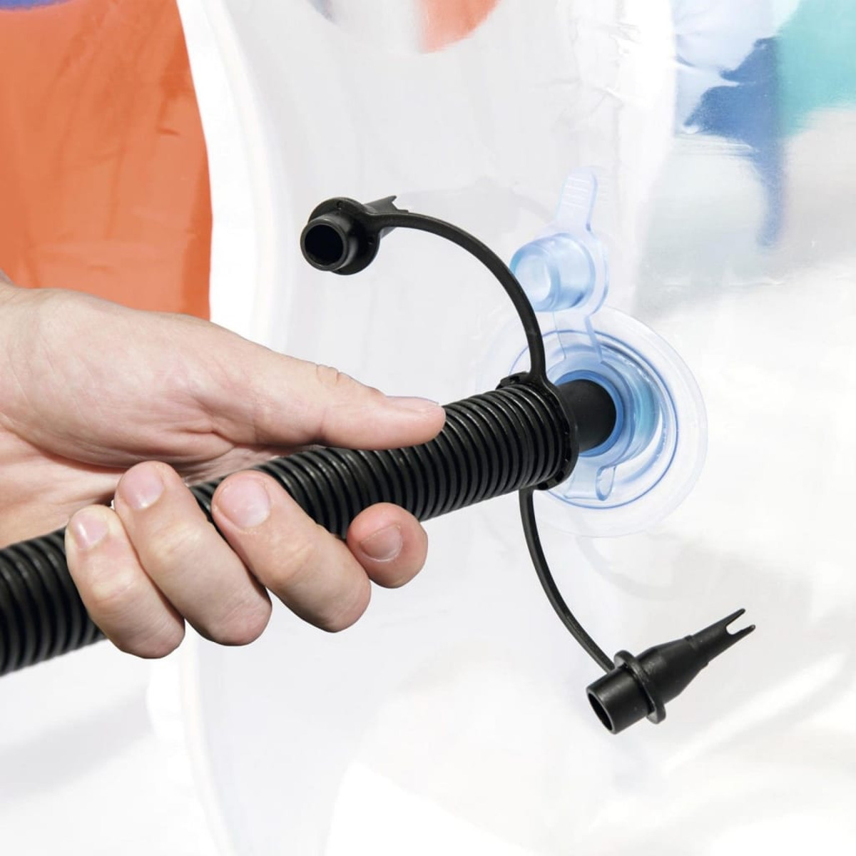 Une main tenant un tuyau noir connecté à une valve gonflable bleue et noire.