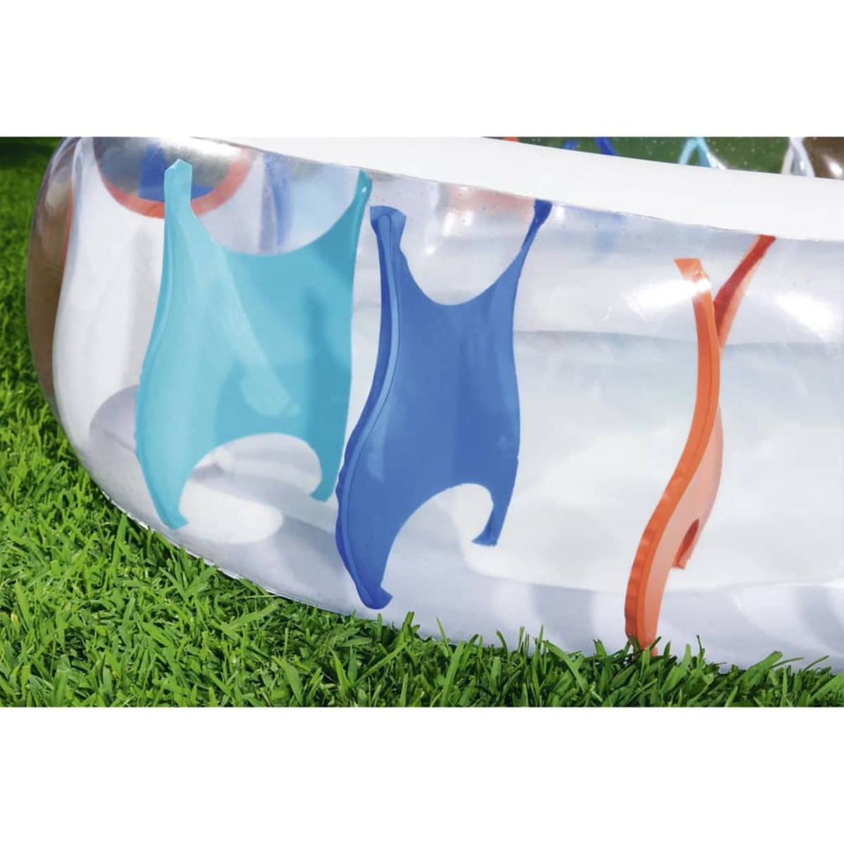 Une piscine gonflable avec des formes bleues et oranges sur le côté. De l'herbe verte en arrière-plan.