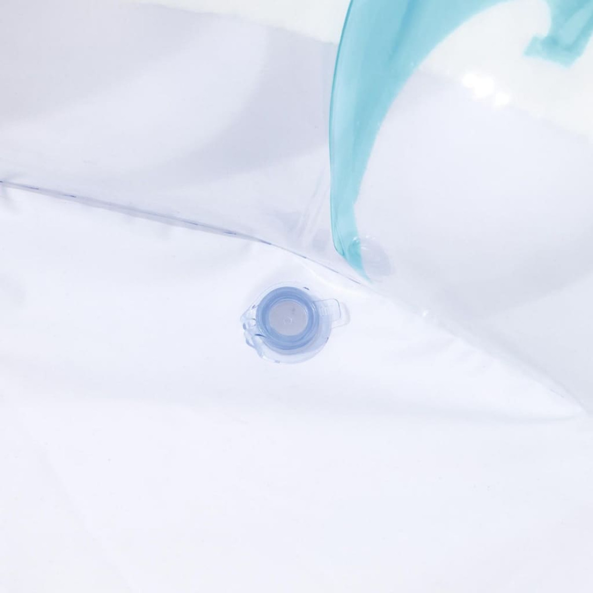 Gros plan sur la valve d'un jouet gonflable sur fond blanc. Une bordure bleue est visible.