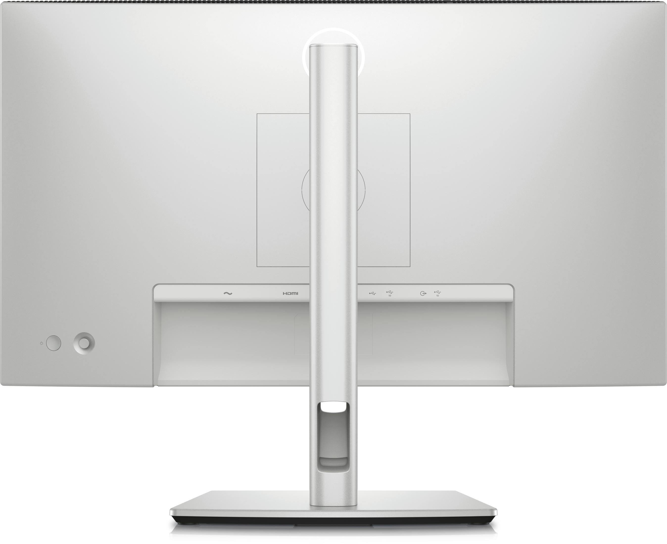 Widok z tyłu białego monitora komputera z portami, podstawą i białym tłem.