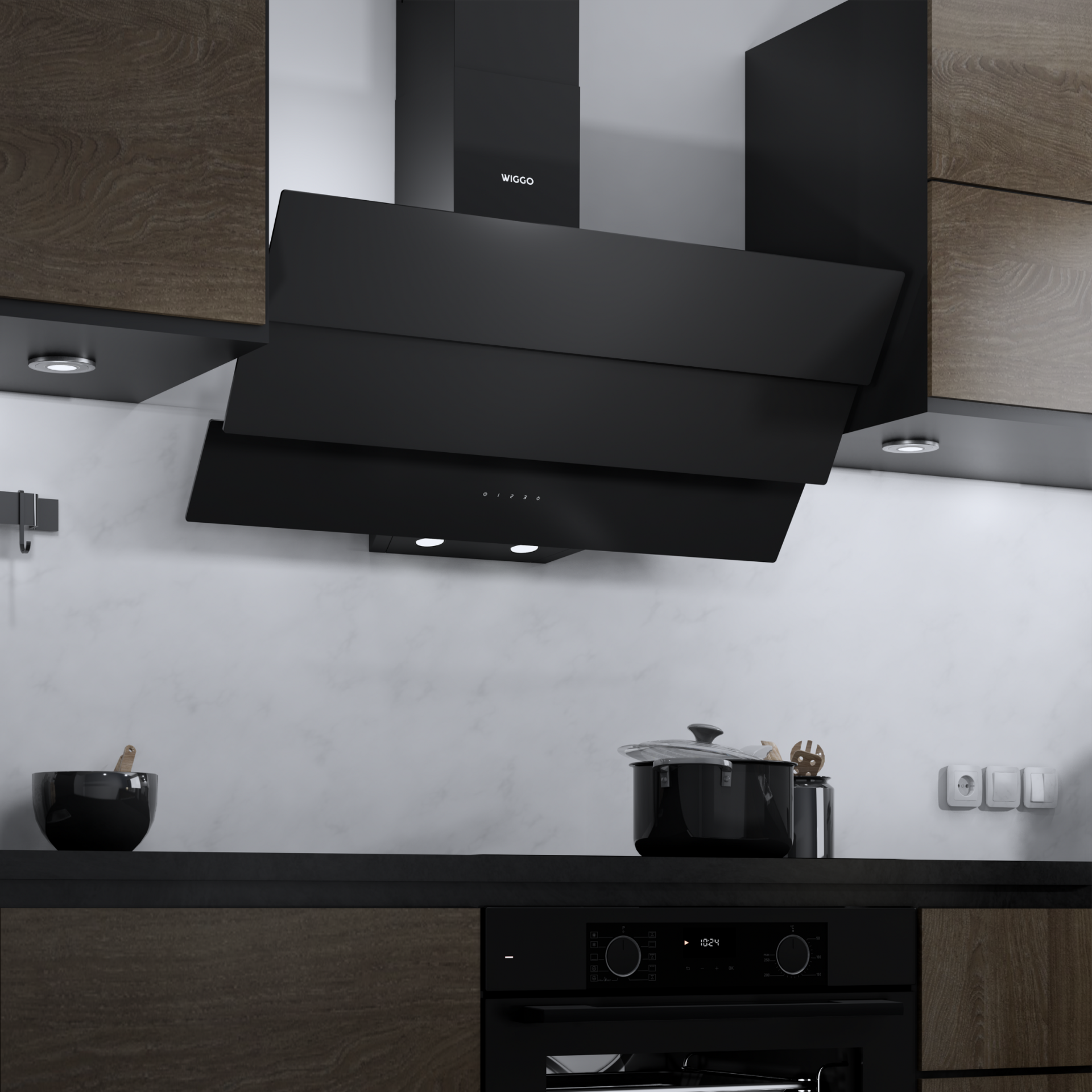 Intérieur de cuisine avec hotte, placards et appareils noirs. Une casserole noire sur le comptoir.