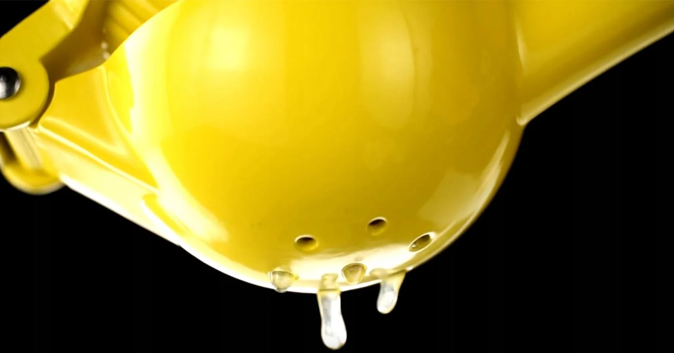 Żółta wyciskarka do cytrusów z kapiącym sokiem.