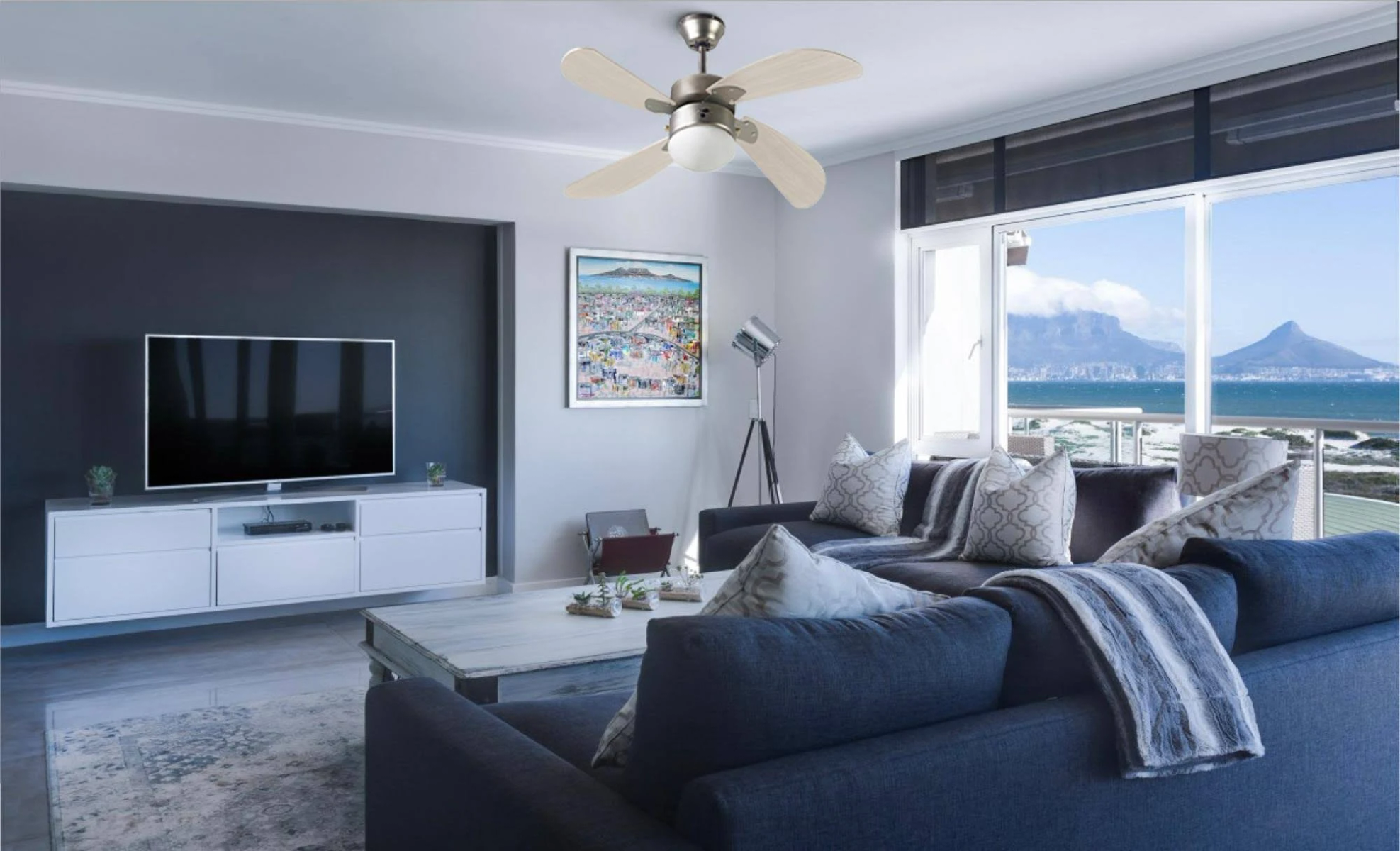 Living room with a ceiling fan, sofa, TV, and art.