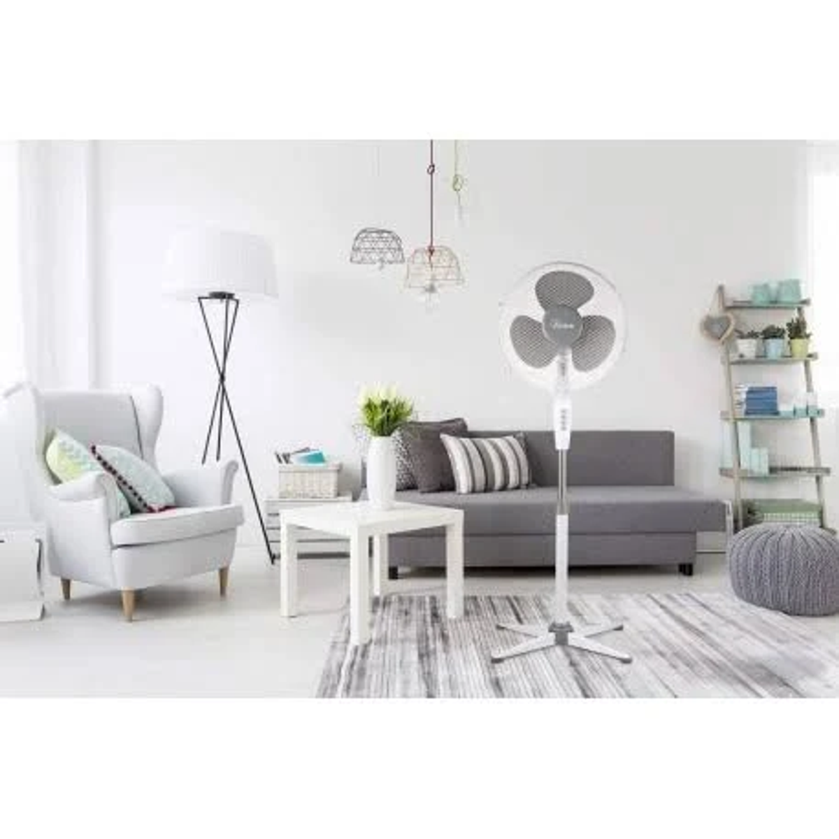 Living room with fan, sofa, armchair, and decorative items.