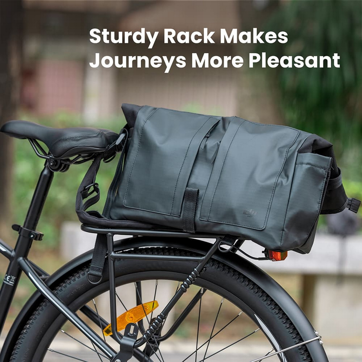 Czarny rower z czarną torbą przymocowaną do tylnego bagażnika. Na torbie napis: Sturdy Rack Makes Journeys More Pleasant.
