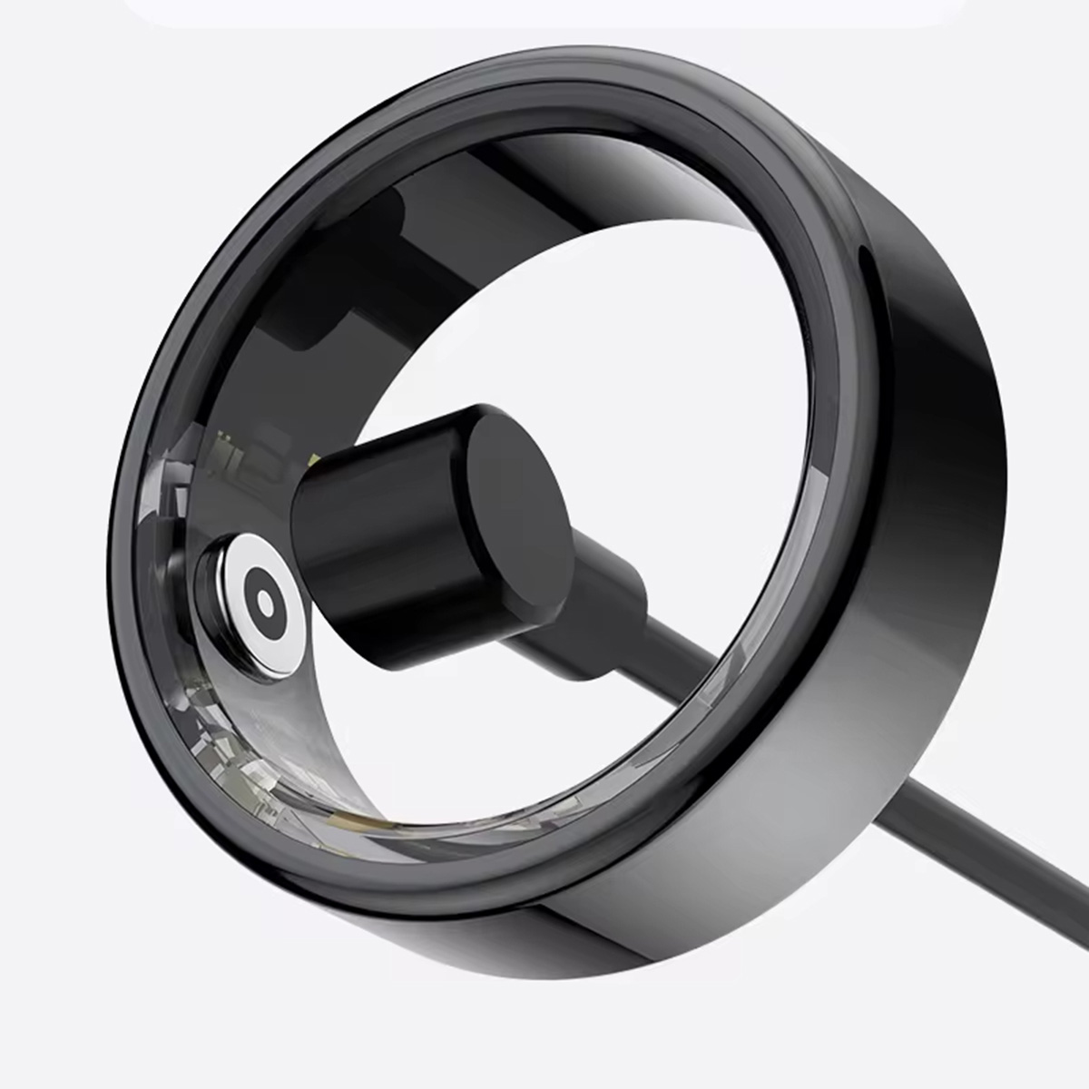 Un anillo inteligente negro con cable de carga. El anillo tiene un diseño elegante y moderno.