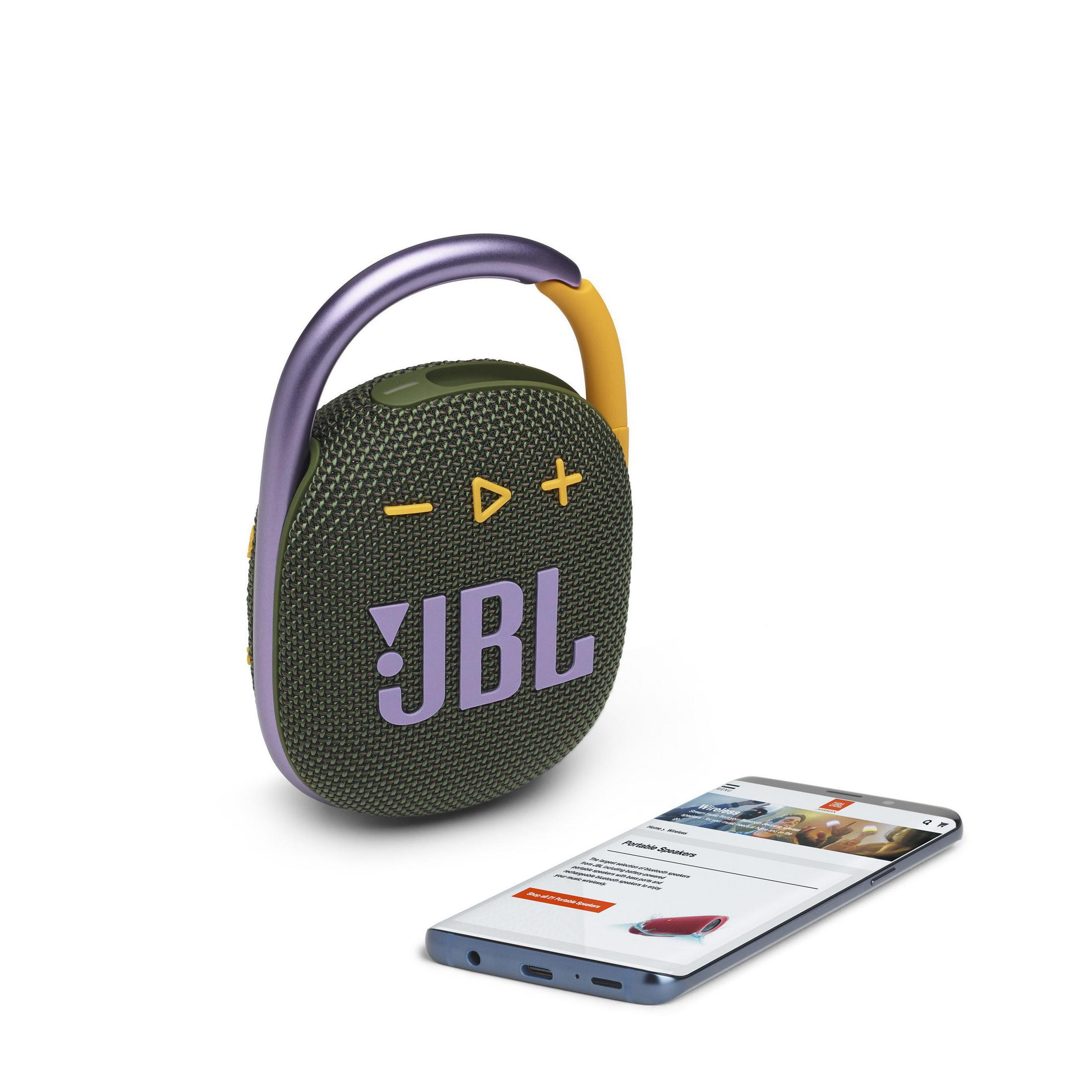 Un altoparlante JBL con dettagli viola accanto a uno smartphone che mostra una pagina web.