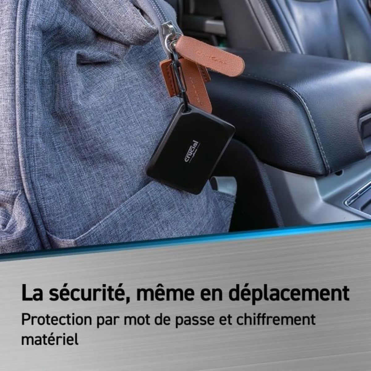 Czarny zewnętrzny dysk twardy zawieszony na breloczku. Tekst po francusku: Bezpieczeństwo, nawet w ruchu.