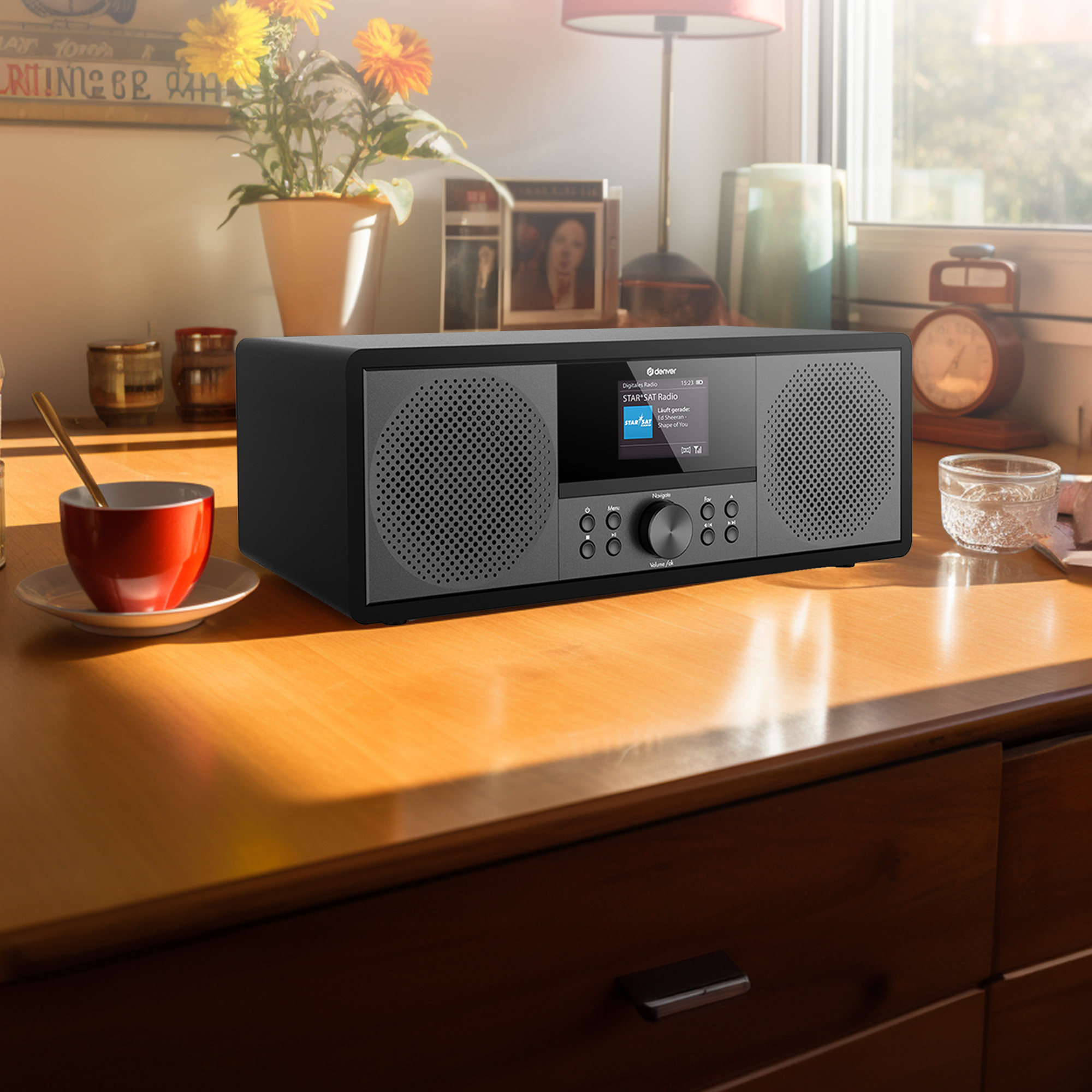 Radio w stylu vintage na drewnianym stole z filiżanką kawy, kwiatami i zegarem.