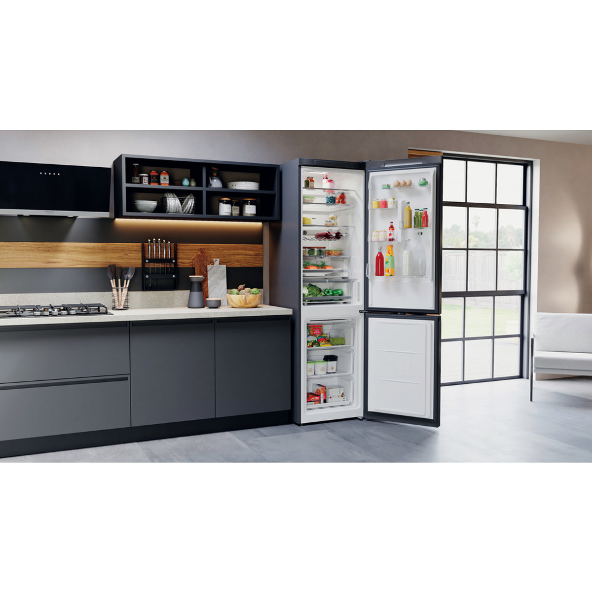 Cocina con nevera abierta. Comida dentro, cajones, estantes y recipientes. Decoración gris y negra.