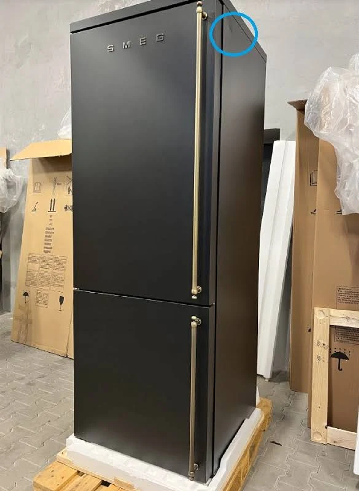 Un primer plano de un refrigerador negro en un almacén. La parte superior es azul.