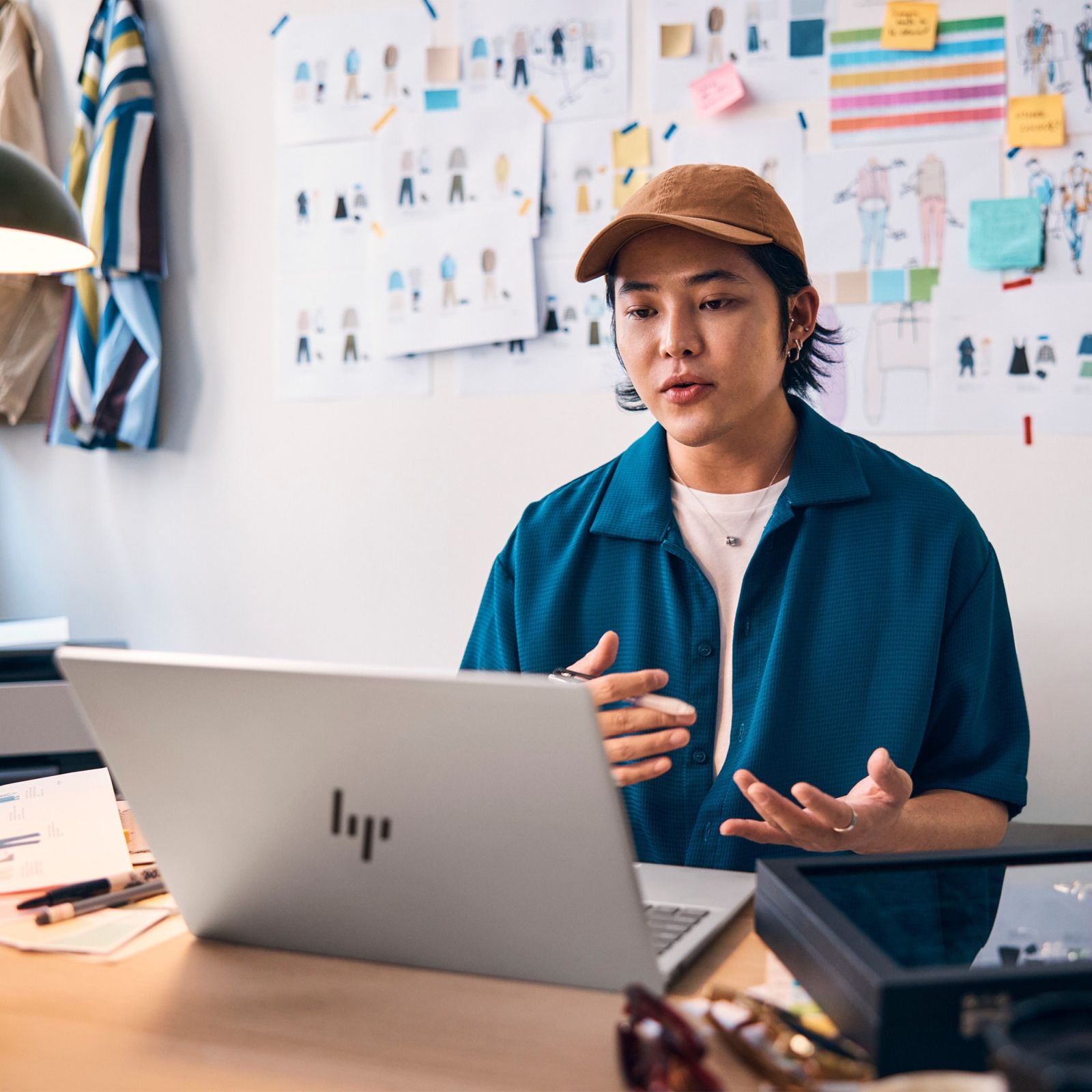 Mężczyzna w czapce i niebieskiej koszuli podczas rozmowy wideo, z laptopem.