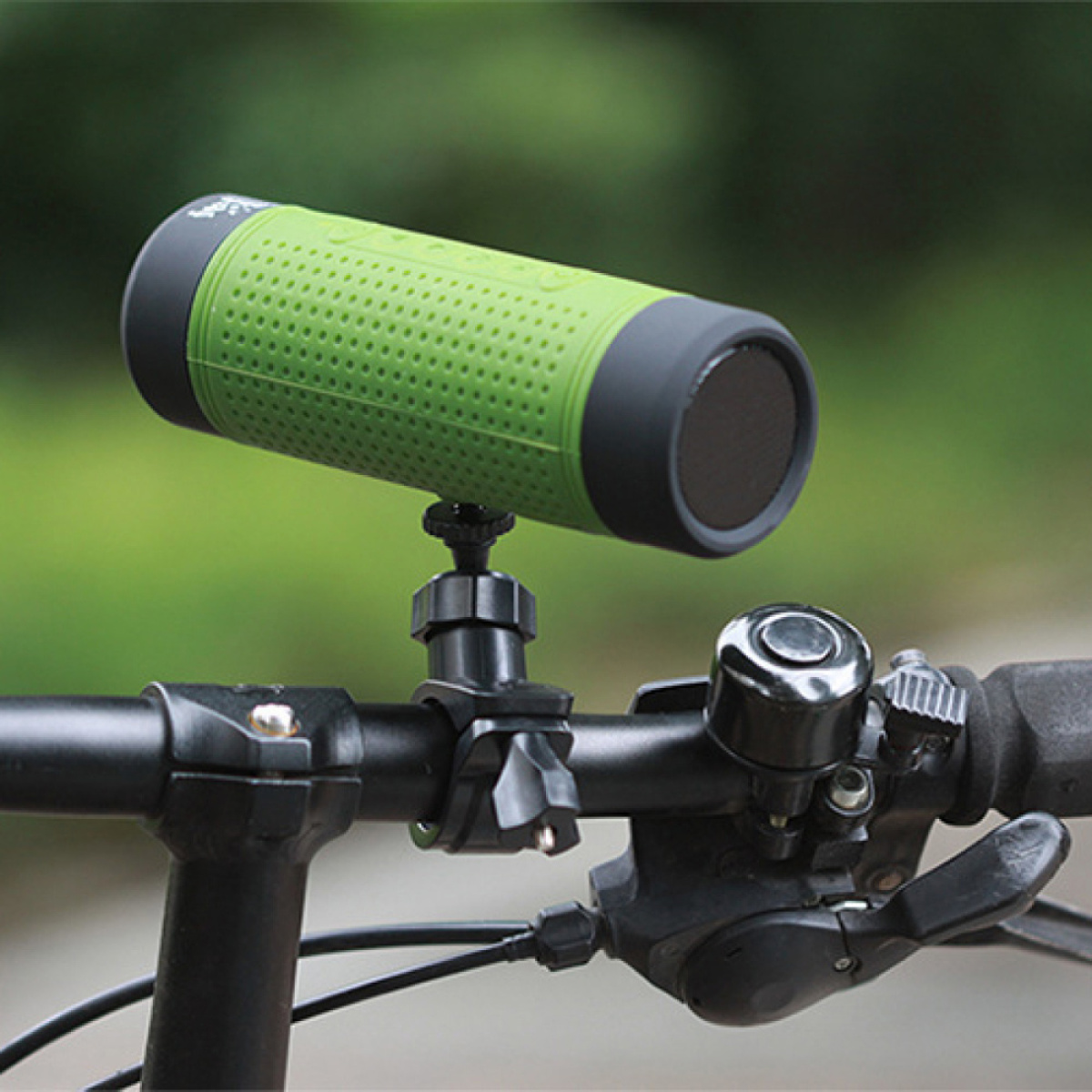 Fahrradlenker mit grünem Lautsprecher. Eine Glocke und eine Gangschaltung sind sichtbar.