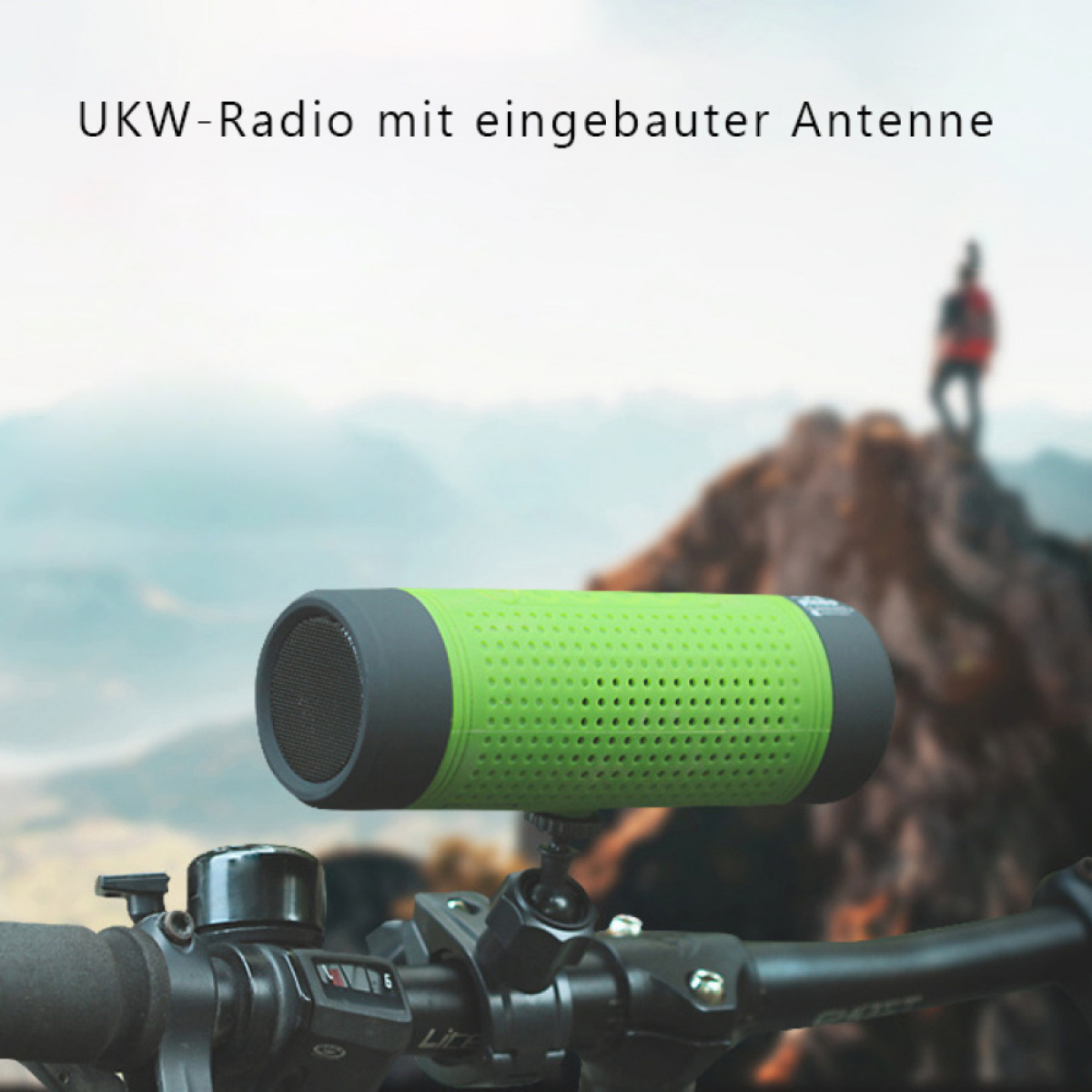 Grüner und schwarzer Lautsprecher an einem Fahrradlenker montiert. Eine Person steht auf einem fernen Berg.