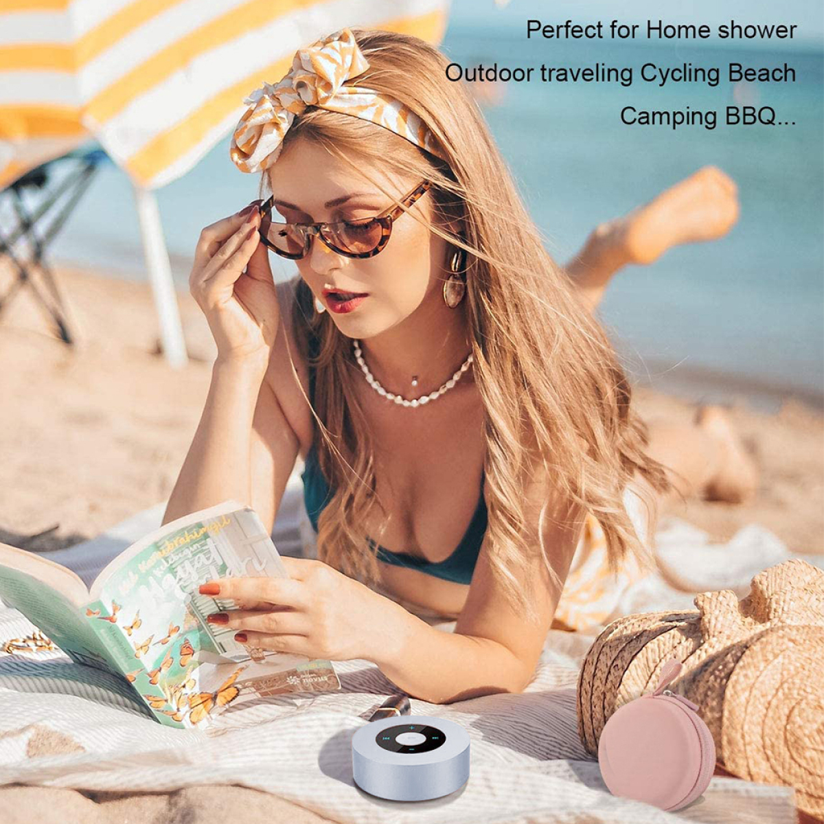 Frau am Strand liest ein Buch, mit einer tragbaren Dusche. Strand und Himmel im Hintergrund.