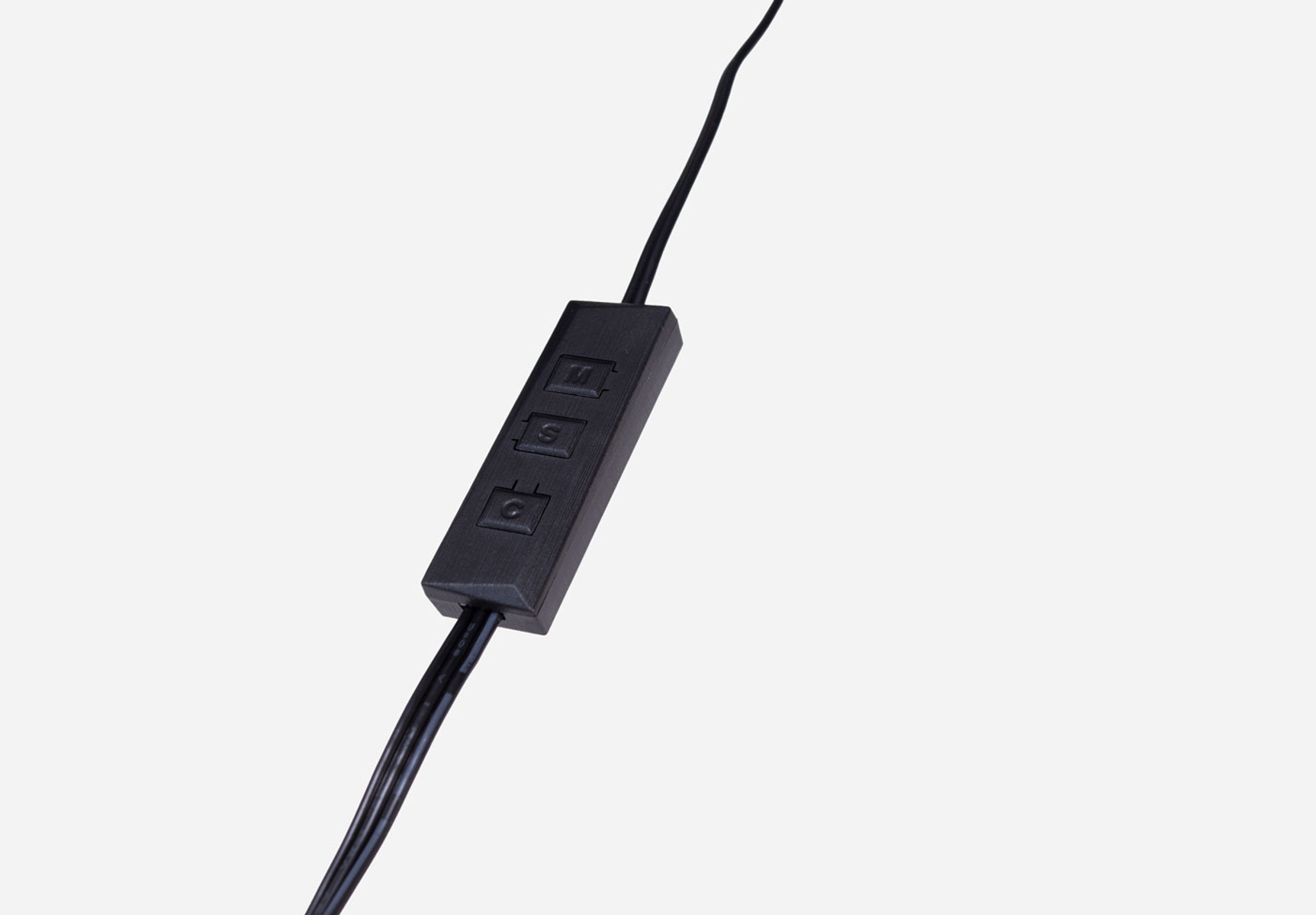 Un panel de control negro con tres botones conectados a cables negros, sobre un fondo claro.